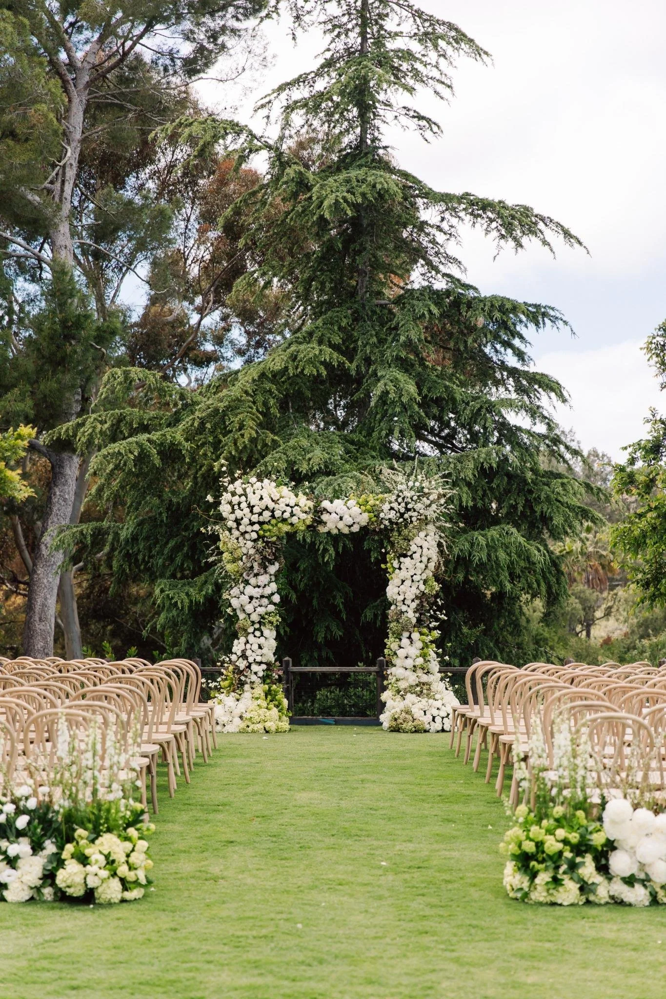 Ceremony floral arch with white blooms at private estate wedding in Rolling Hills Estates, California