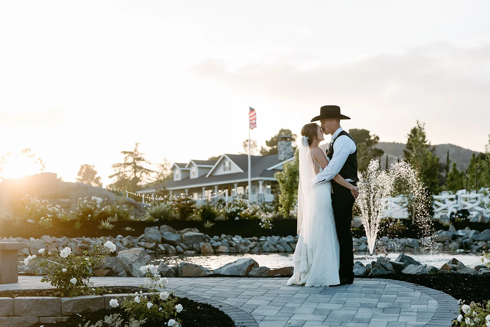 Bride and groom portrait at sunset with private estate and fountain in the background