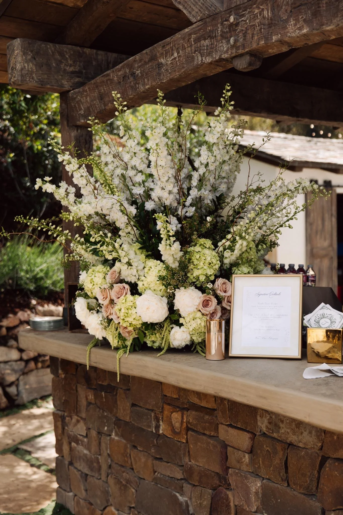 Custom bar setup with large floral arrangement at private estate wedding in Rolling Hills Estates, California
