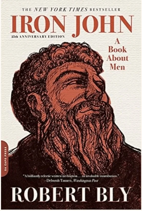 Book cover of 'Iron John: A Book About Men' by Robert Bly, 25th Anniversary Edition, featuring an illustration of a bearded man with curly hair.