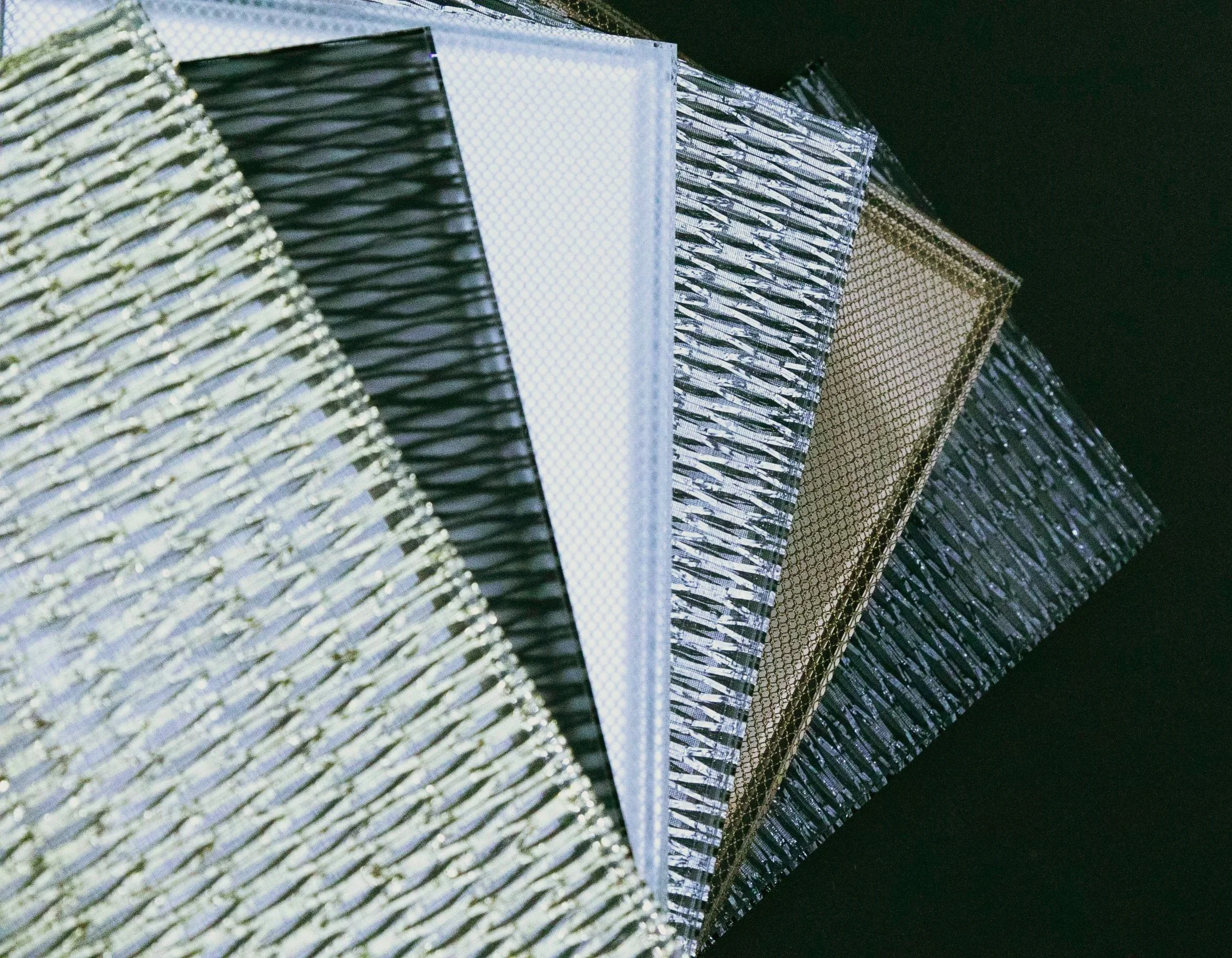 A set of metallic glass samples with different types of interlayers creating a different effect in each laminated composition.