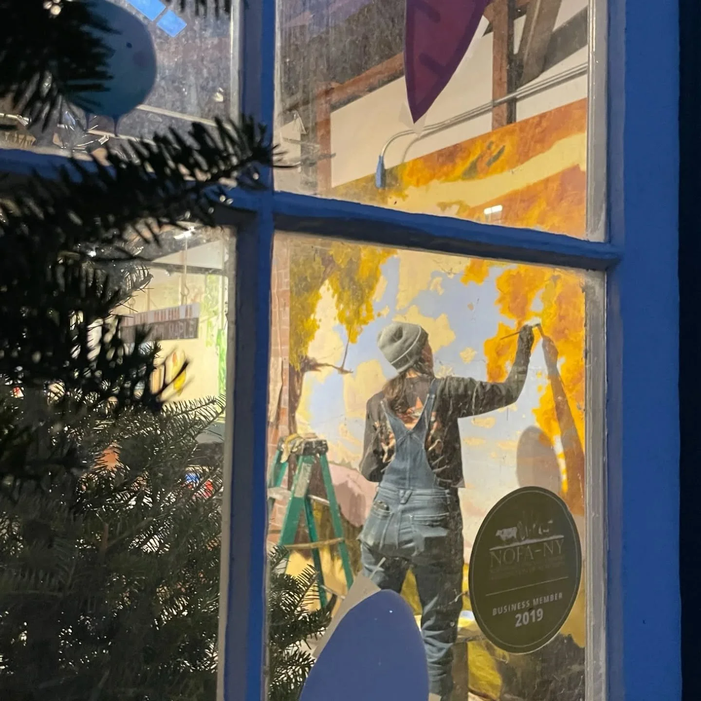 Take a peek! Sasha Glinski is painting a mural in the Cooperstown Farmers' Market. The mural will eventually extend the whole length of the west side of the Market, providing a welcoming and whimsical atmosphere for the Market. 

Sasha sells her prin