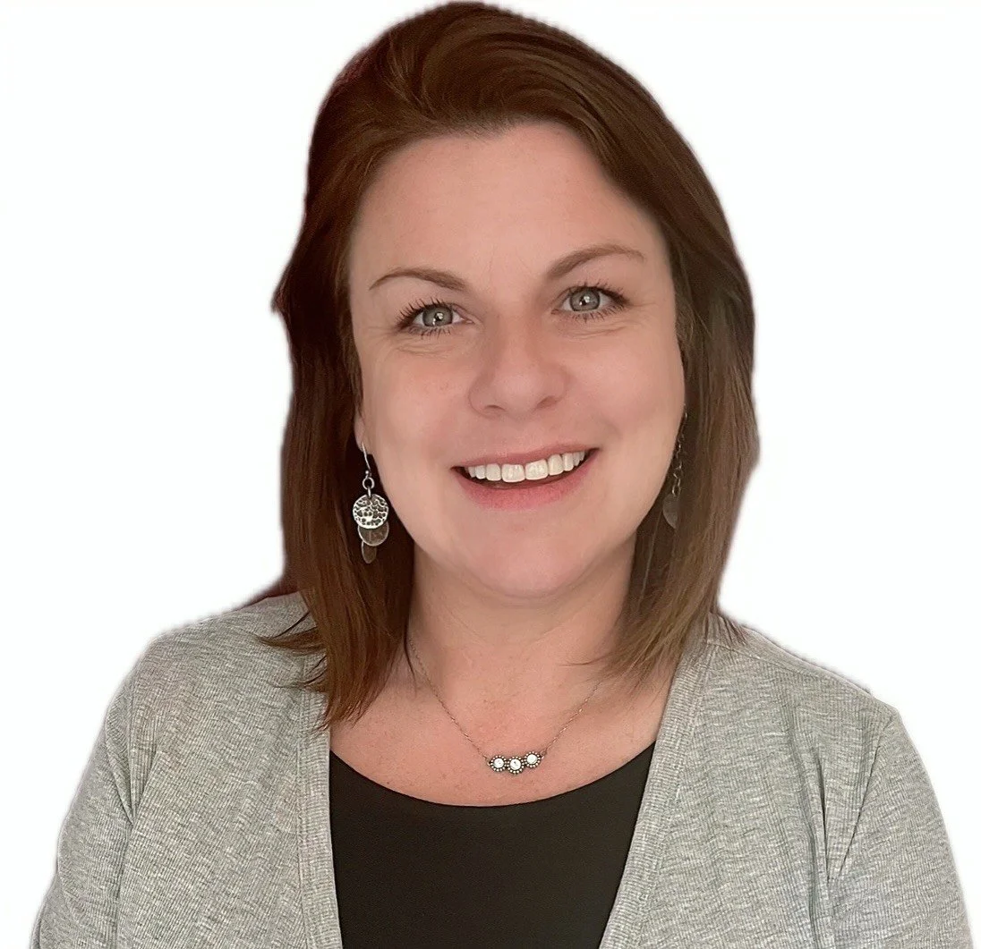 A woman with shoulder-length brown hair and light skin, smiling, wearing a gray blazer, black top, and jewelry, against a white background.