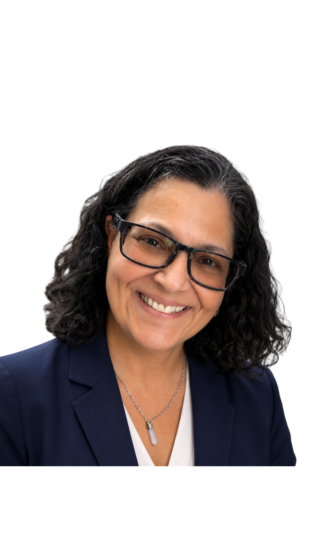 A woman with curly dark hair wearing glasses, a navy blazer, a white shirt, and a silver necklace, smiling against a white background.