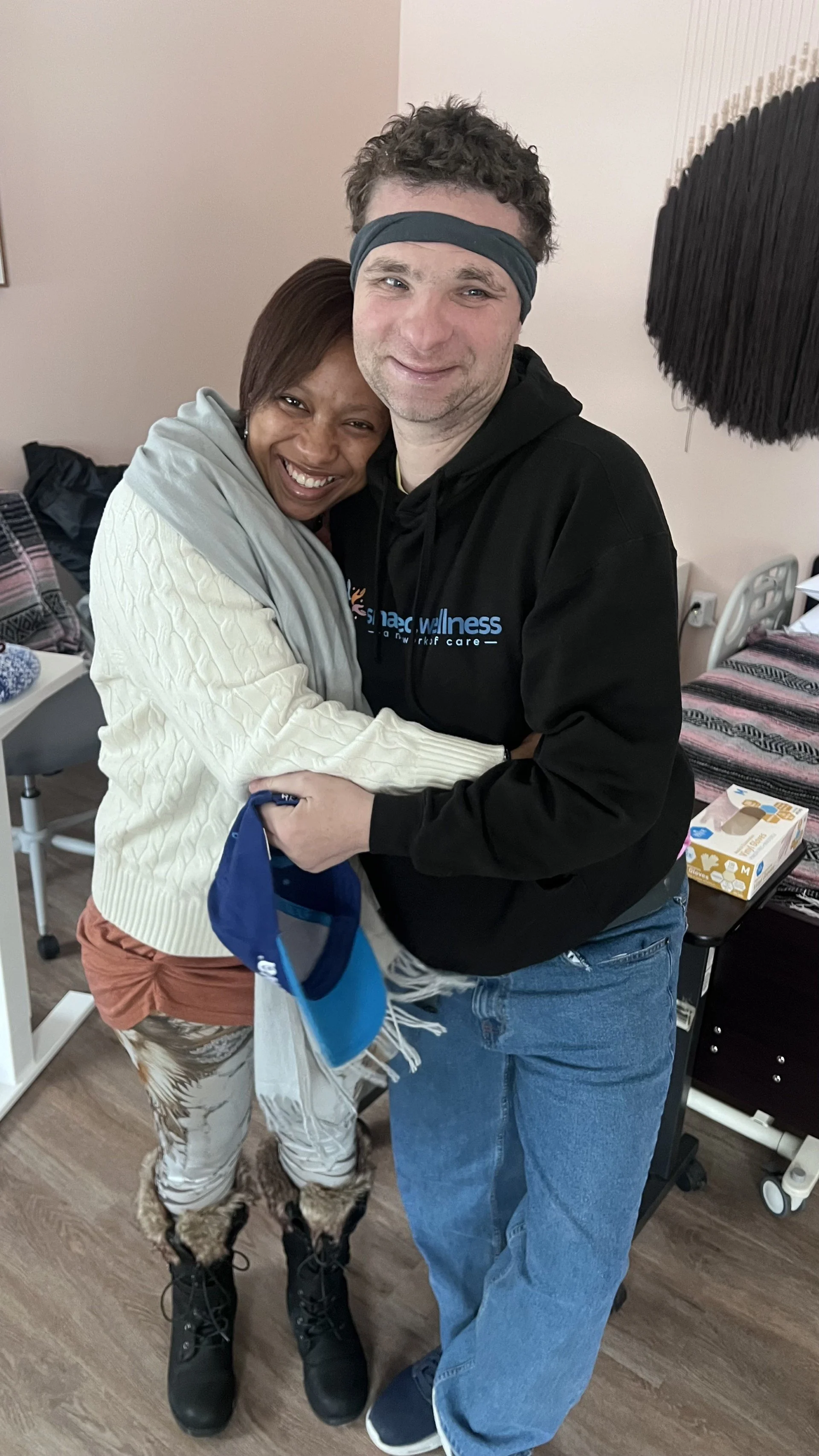 Two women posing indoors, both making peace signs with their hands and smiling at the camera.