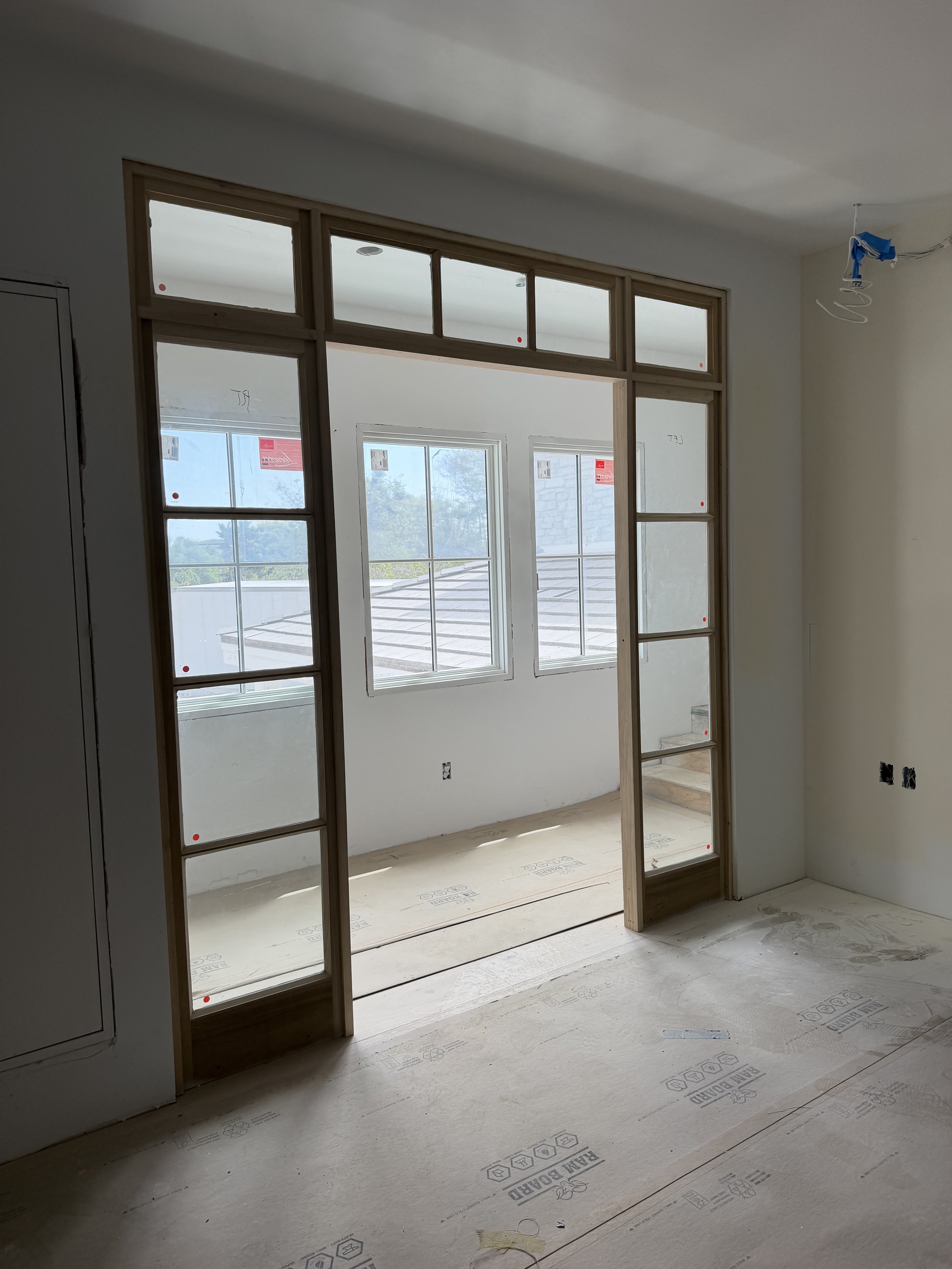 Interior of a room under construction with new window framing, bare walls, and unfinished flooring. Del Mar
