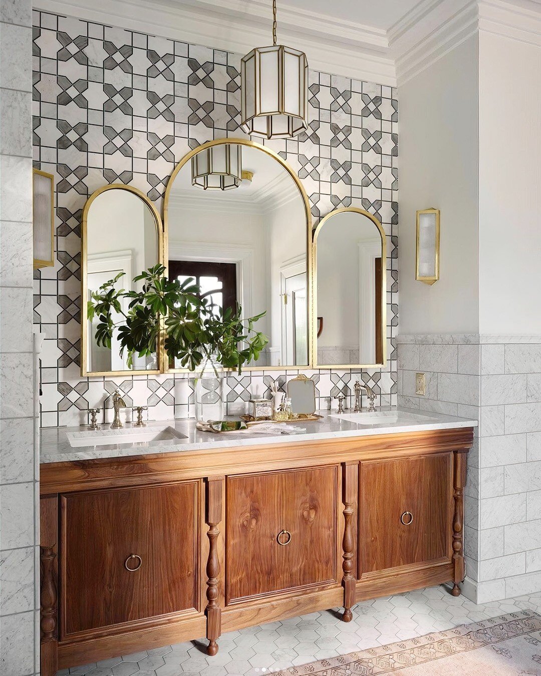 A pair of Daze Pendants from @curreyco set off this stunning bathroom space by @joannagaines. Panes of painted milky glass are set into brass window-like panes, providing a soft, warm glow with lots of fine detail work.

#witfordluxury #curreyco #joa