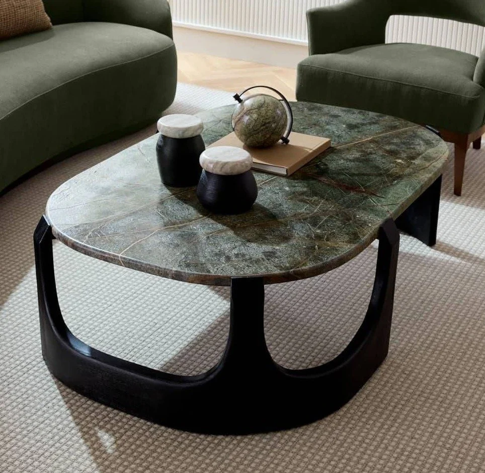 The Lorena Coffee Table from @arteriorshome embodies sculptural strength and organic grace.

A striking oval top of veined jungle marble rests effortlessly atop a carved mango wood base in a rich ebony finish. The natural variations in both stone and