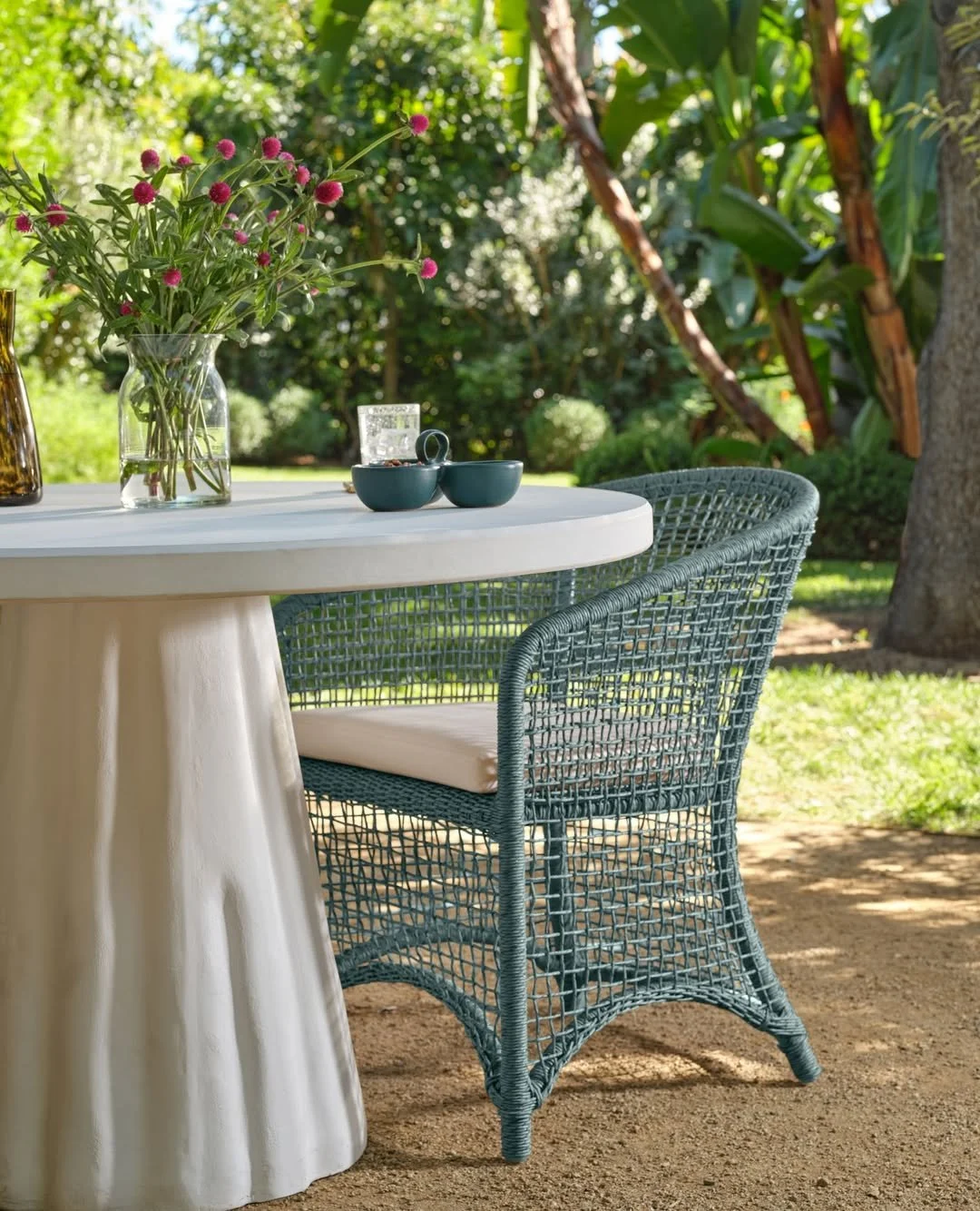 Serene blue and effortless elegance set the tone for a sunlit outdoor dining moment. The Grady Dining Table and Helena Dining Chair from @madegoods bring refined ease to the open air &mdash; crisp, calm, and beautifully composed.