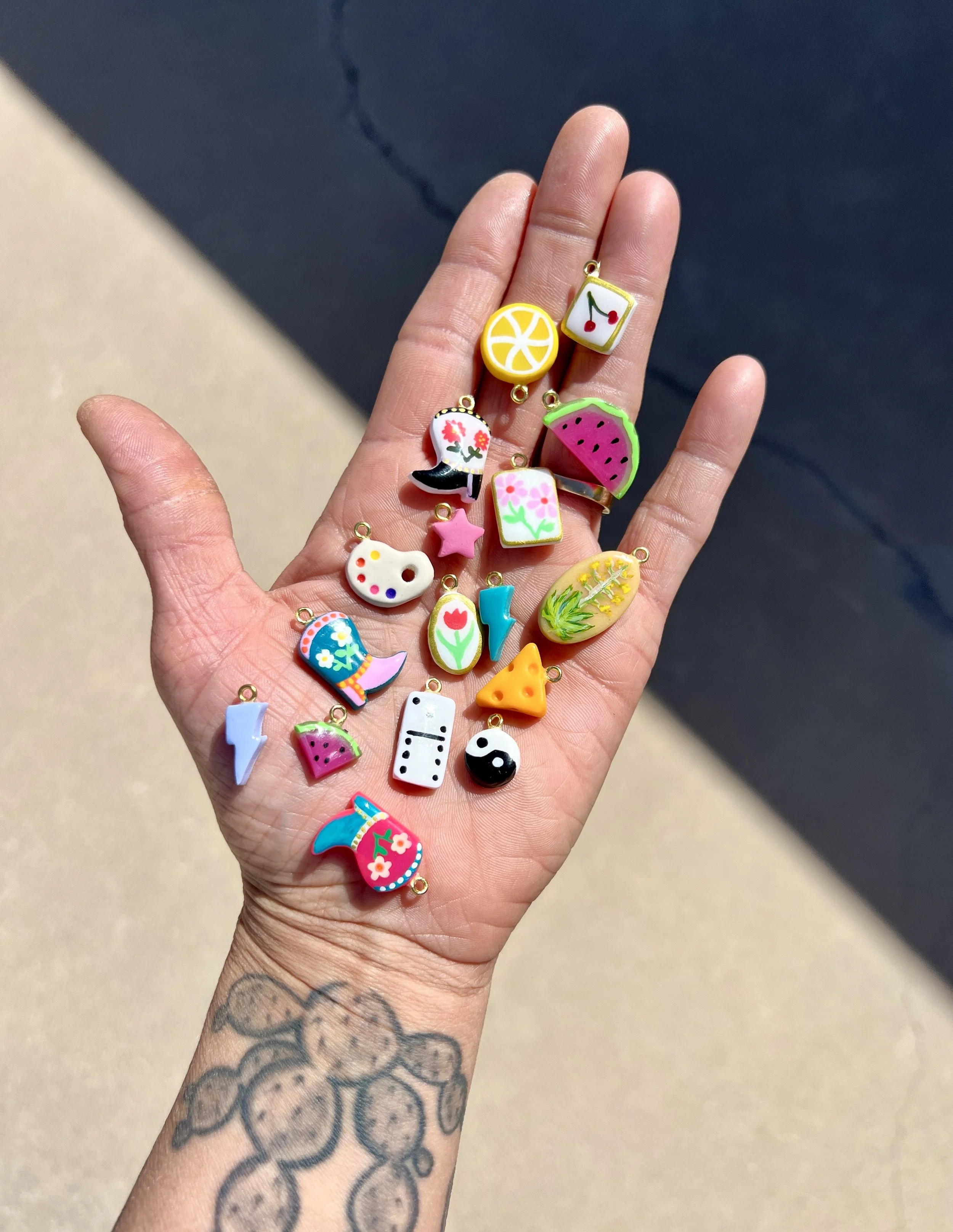 mini handmade polymer clay charms held in hand