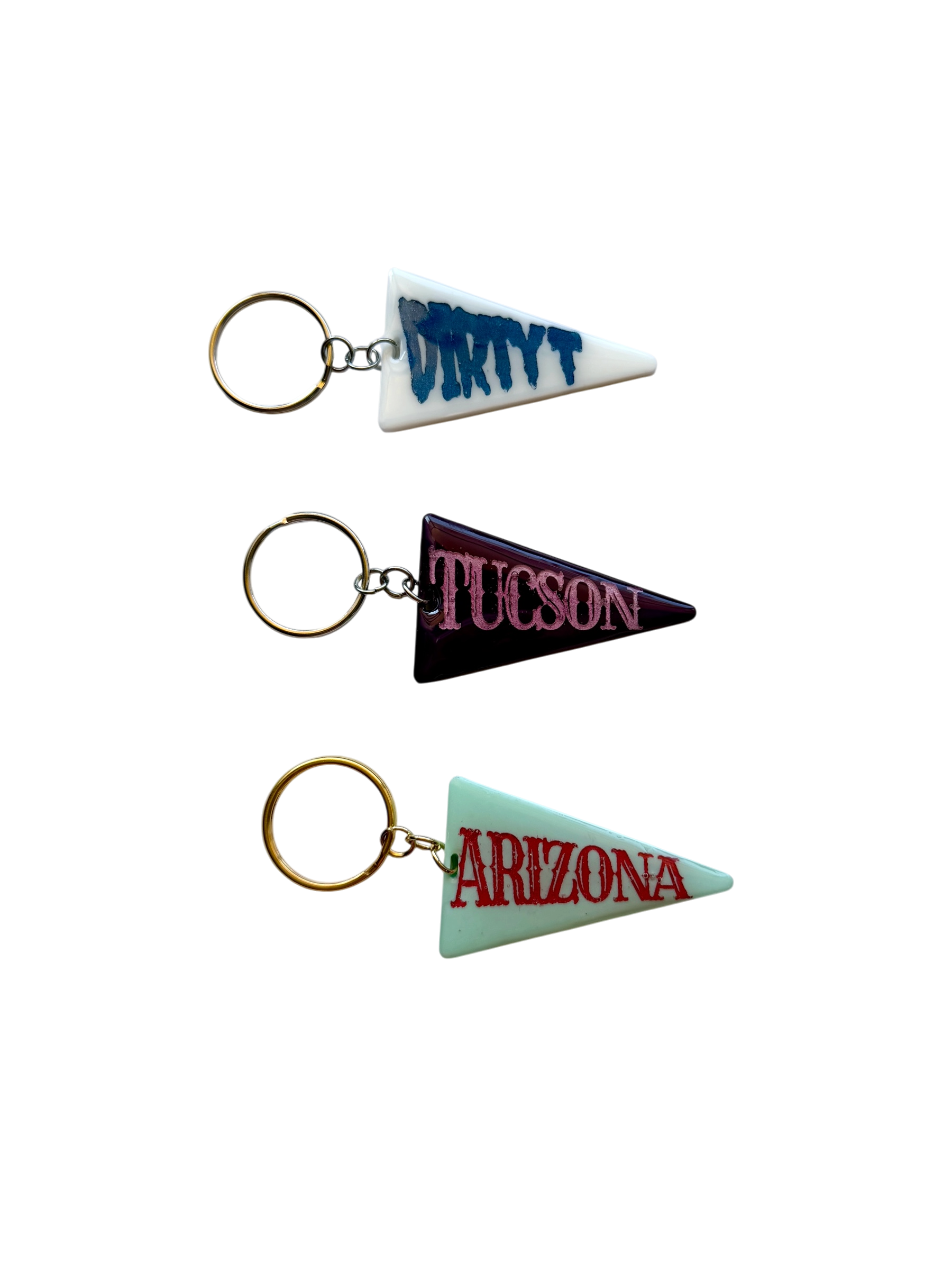 Colorful handmade pennant keychains featuring Arizona, Tucson, and Dirty T designs with vintage souvenir style.