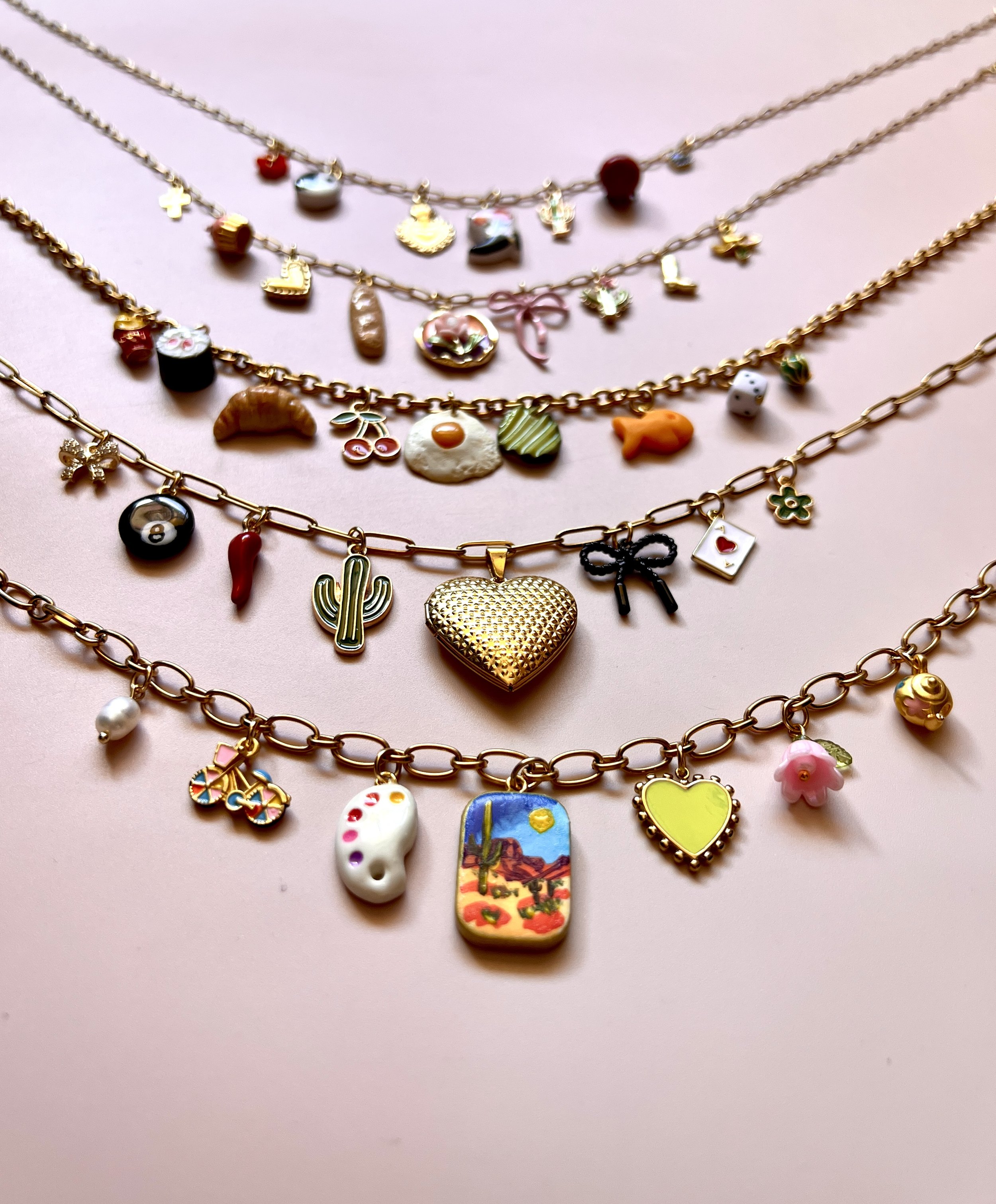 row of necklaces featuring handmade charms in different shapes and sizes