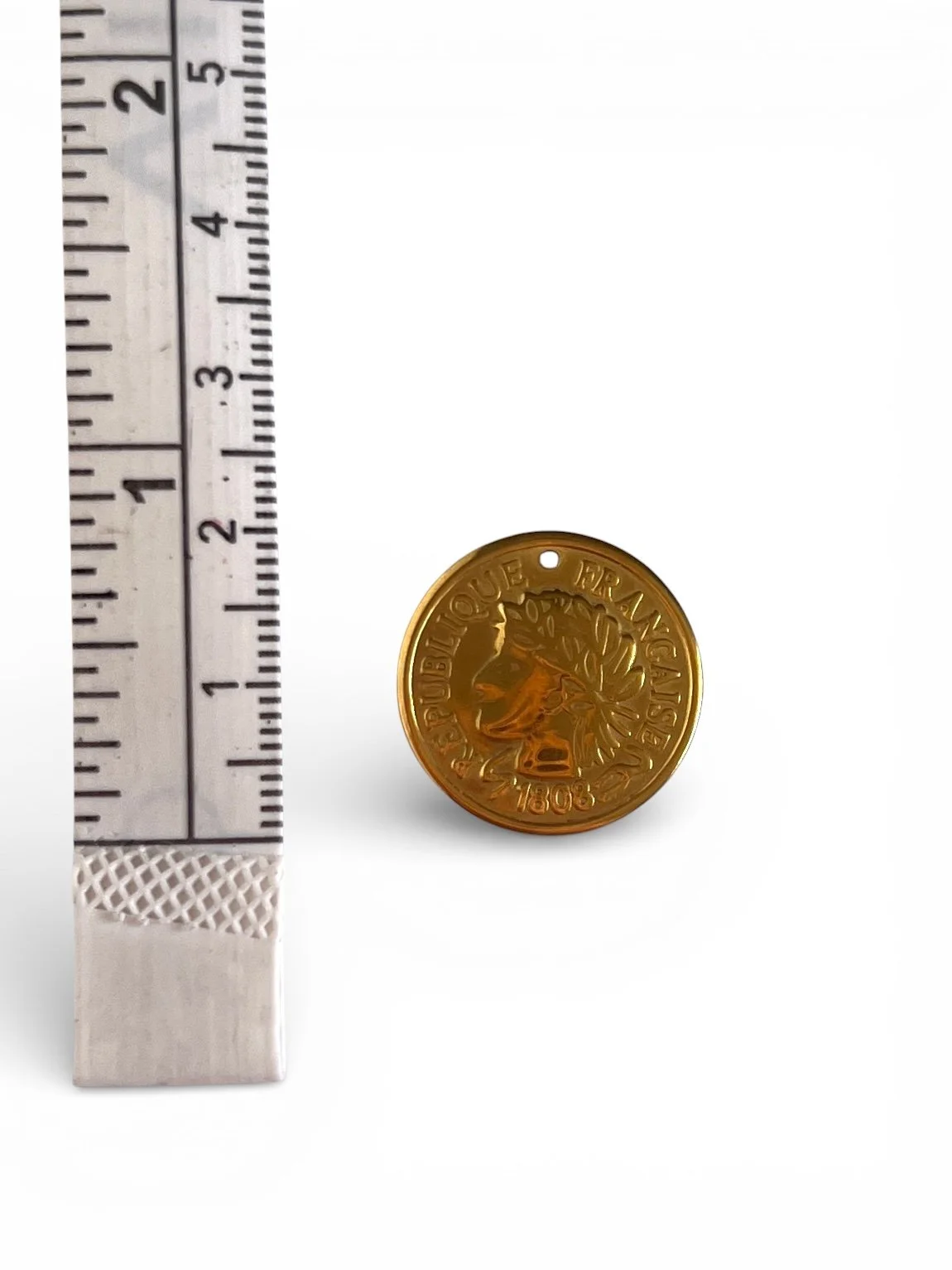 Gold round coin charm with engraved classical profile design