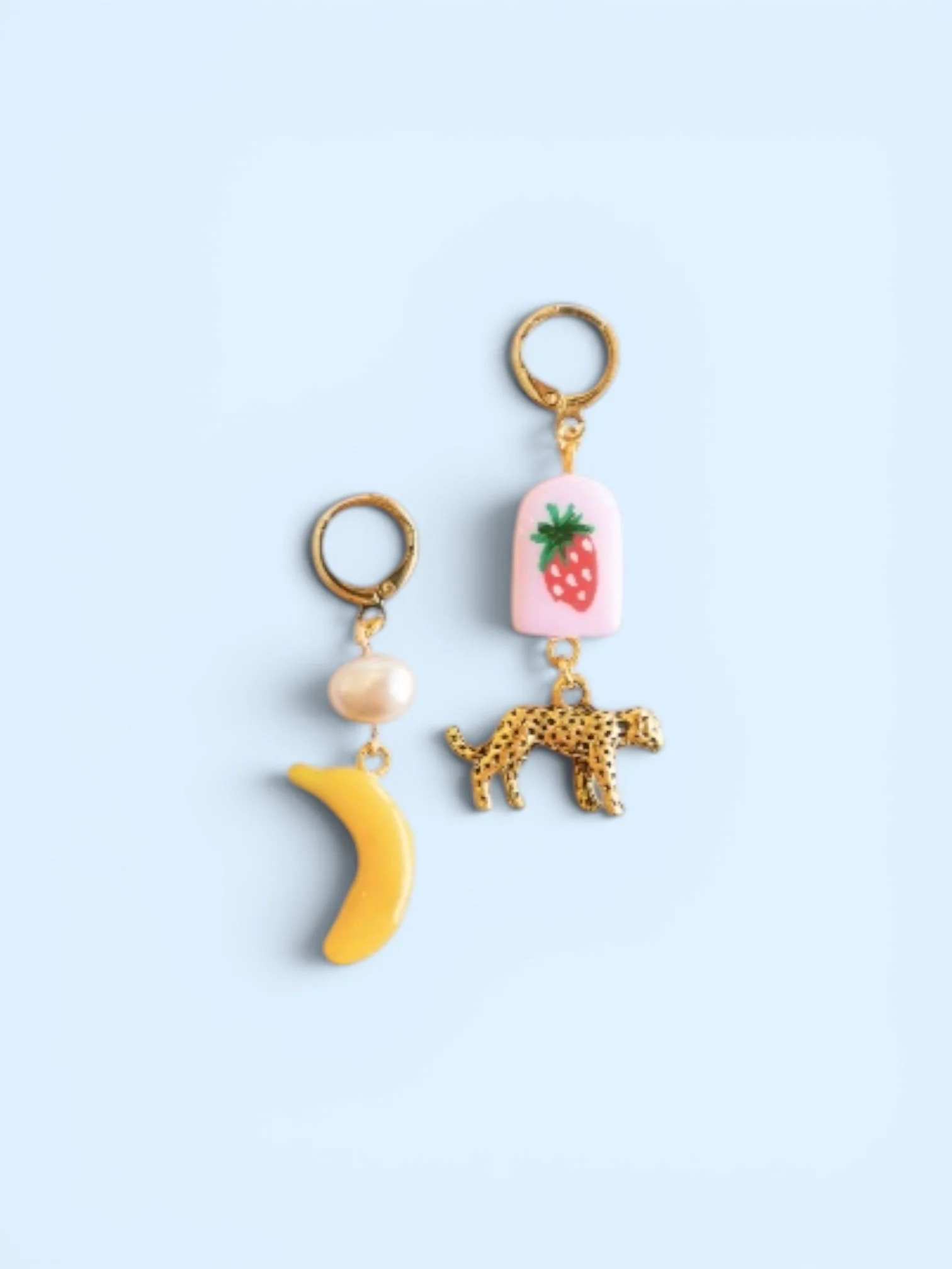 Lola mismatched earrings with banana charm, pearl accent, strawberry drink charm, and leopard charm on gold hoops