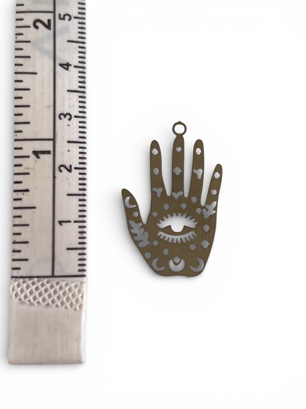 Silver hamsa hand charm with cutout evil eye and celestial symbols