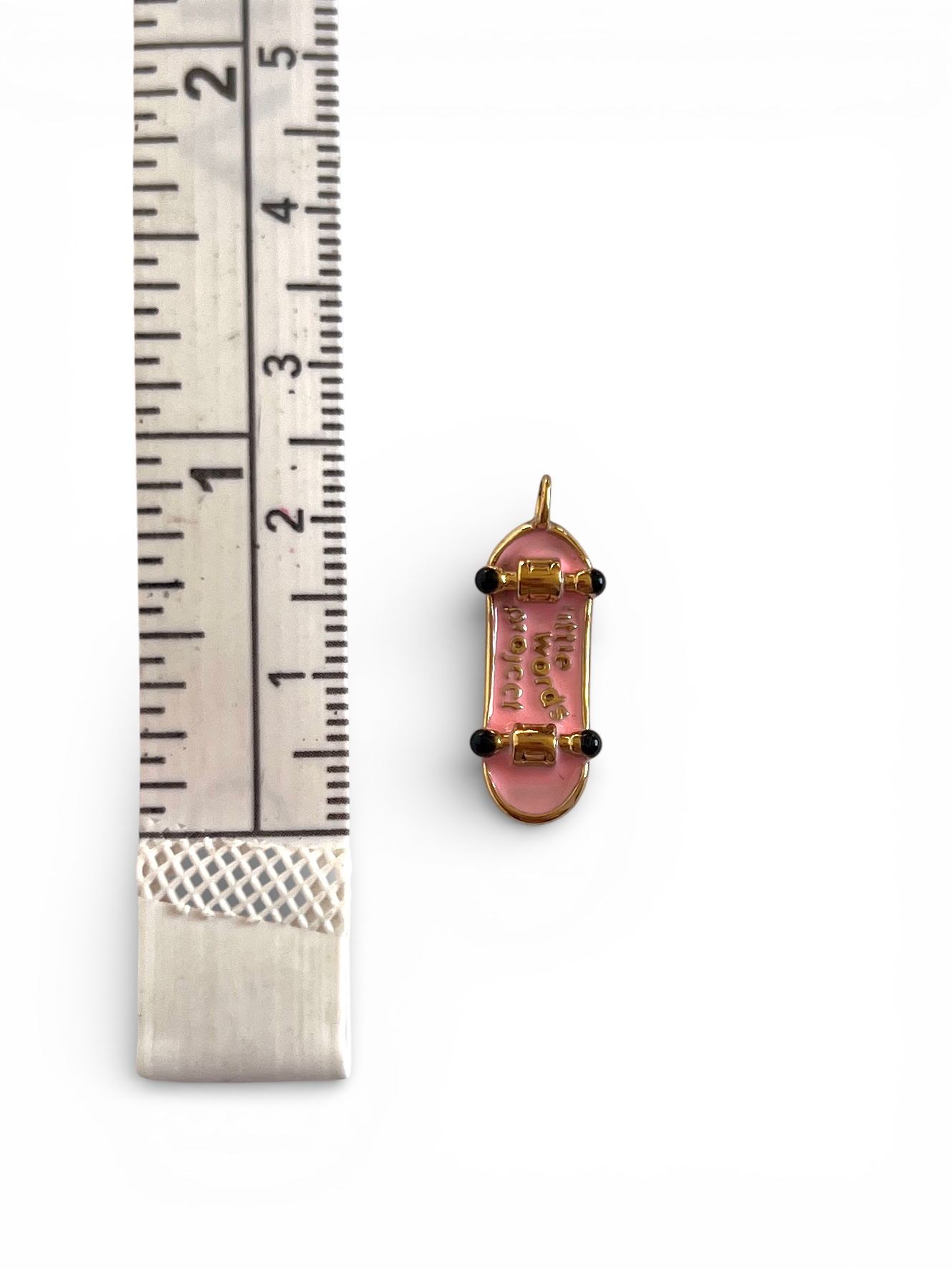 pink and gold skateboard charm