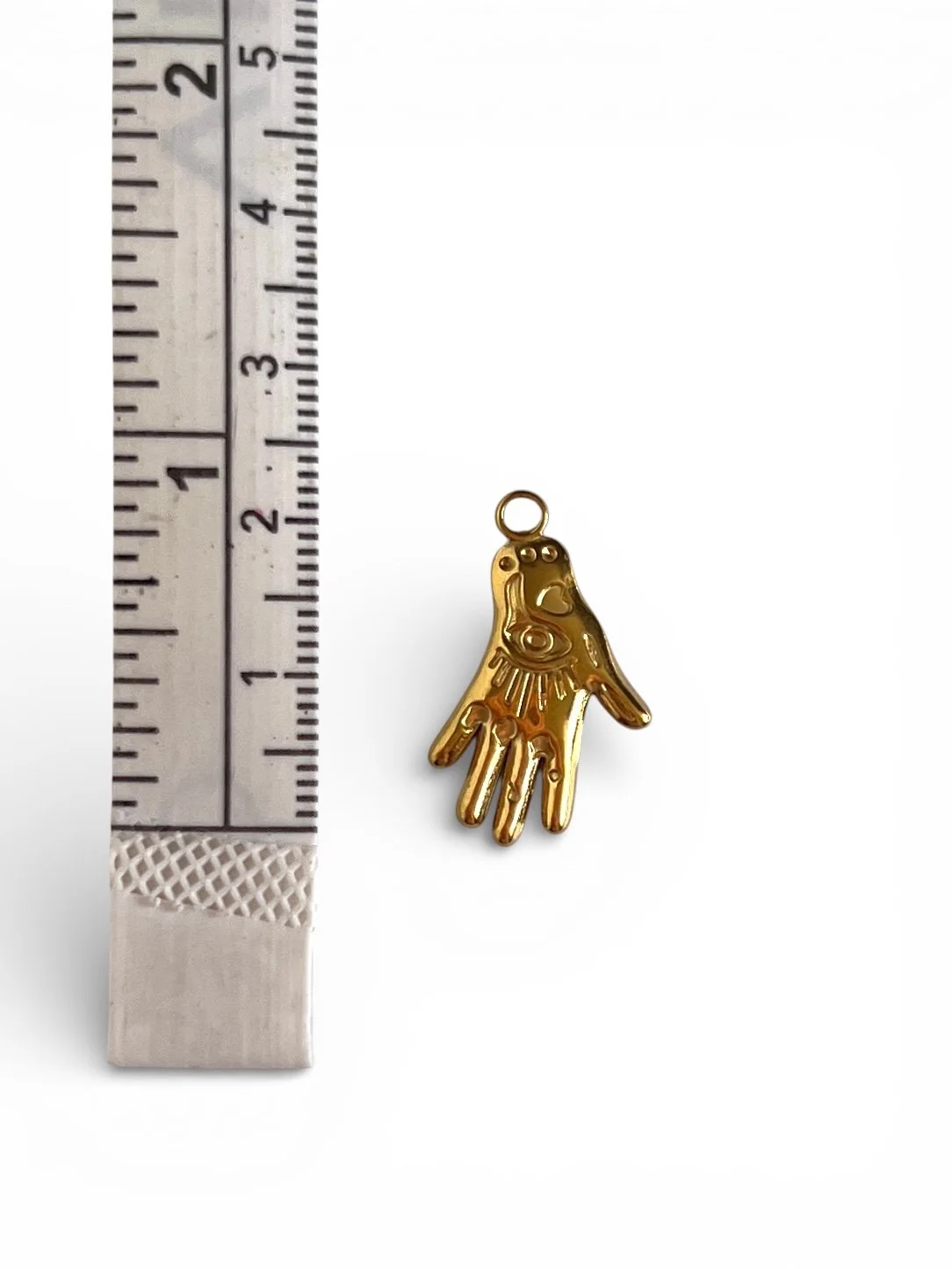 gold hand charm with engraved details