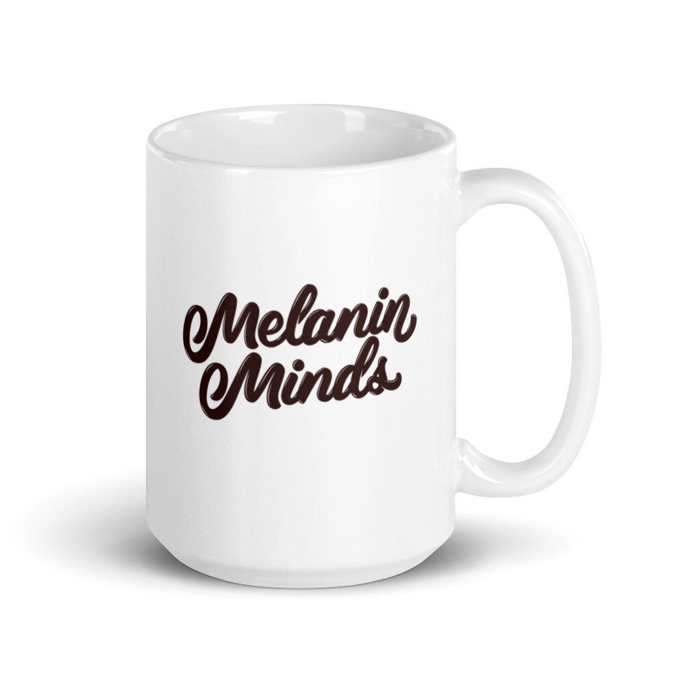 White 15 oz mug with handle on the right, featuring dark brown Melanin Minds logo