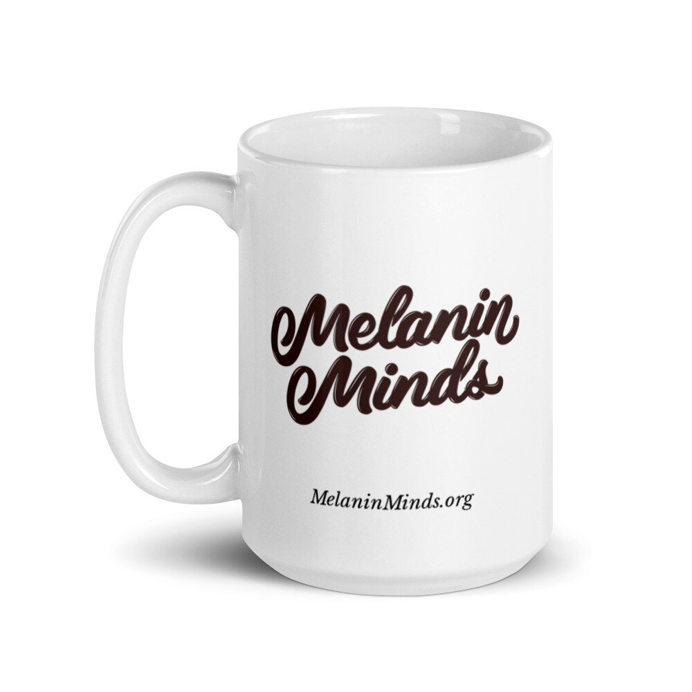 White 15 oz mug with handle on the right, featuring dark brown Melanin Minds logo & MelaninMinds.org