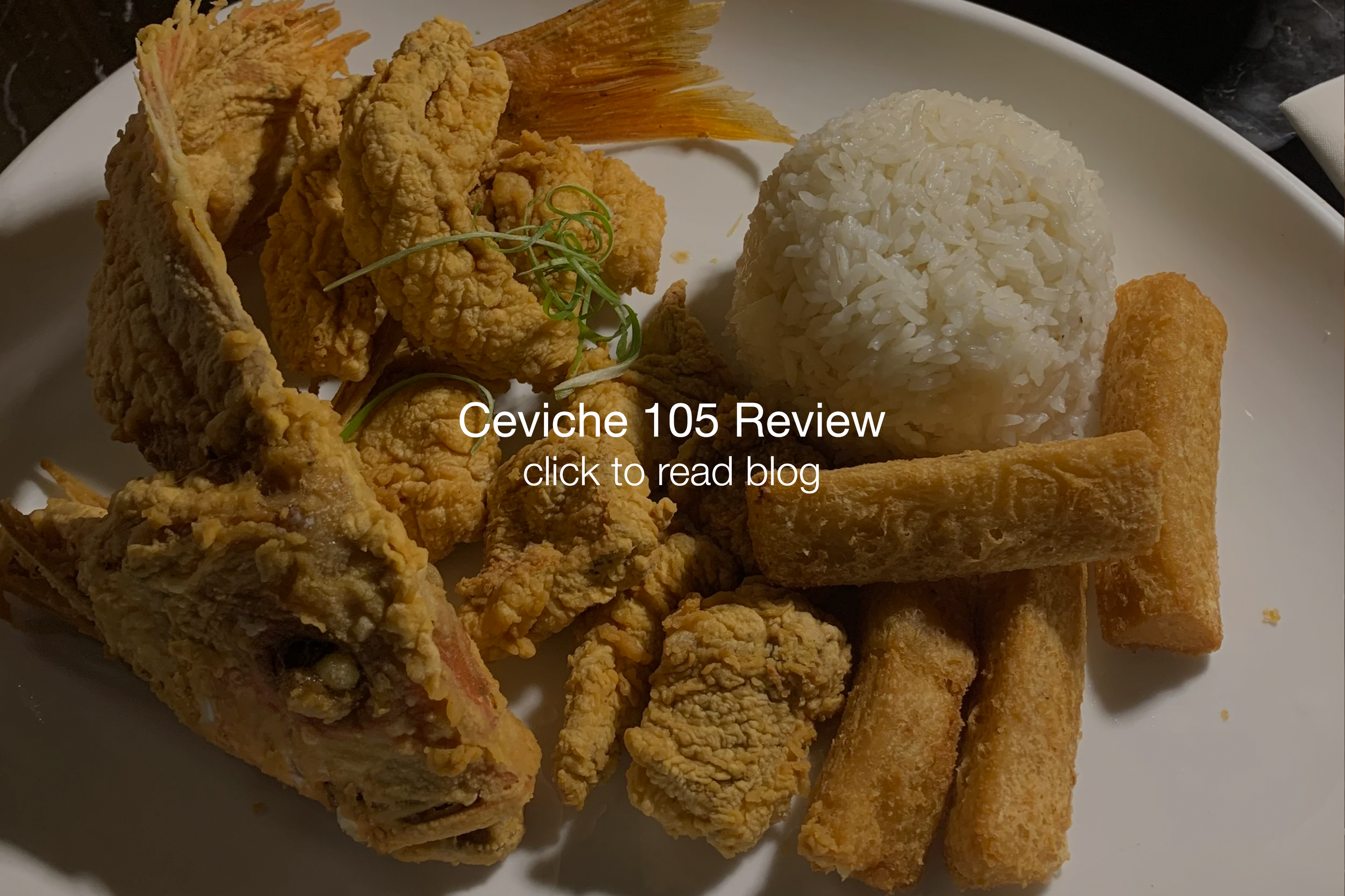 A plate of Filipino food featuring fried fish, rice, fried banana or plantain, fried seafood sticks, and fried chicken strips. The dish is garnished with green microgreens.