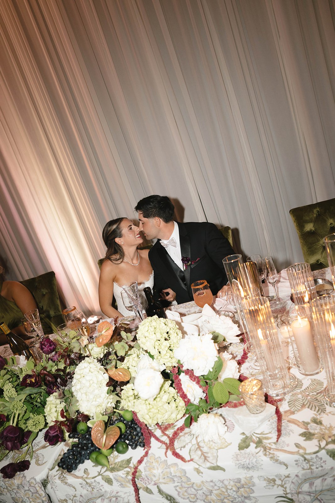 Luxury California wedding reception featuring a candlelit table with lush florals, layered linens, and elegant olive velvet chairs. A timeless, editorial-inspired design creating a romantic and unforgettable guest experience.

Luxury California weddi