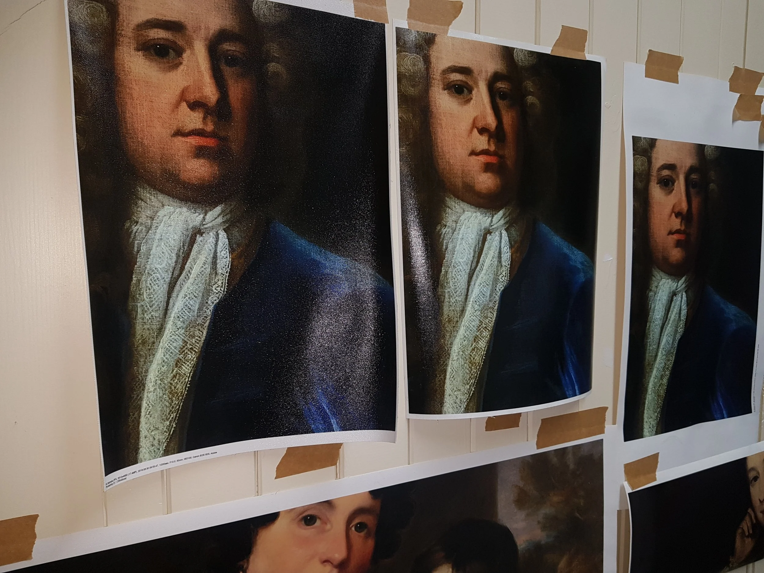 Multiple prints of a portrait of a woman with curly hair, blue clothing, and lace collar taped to a wall.