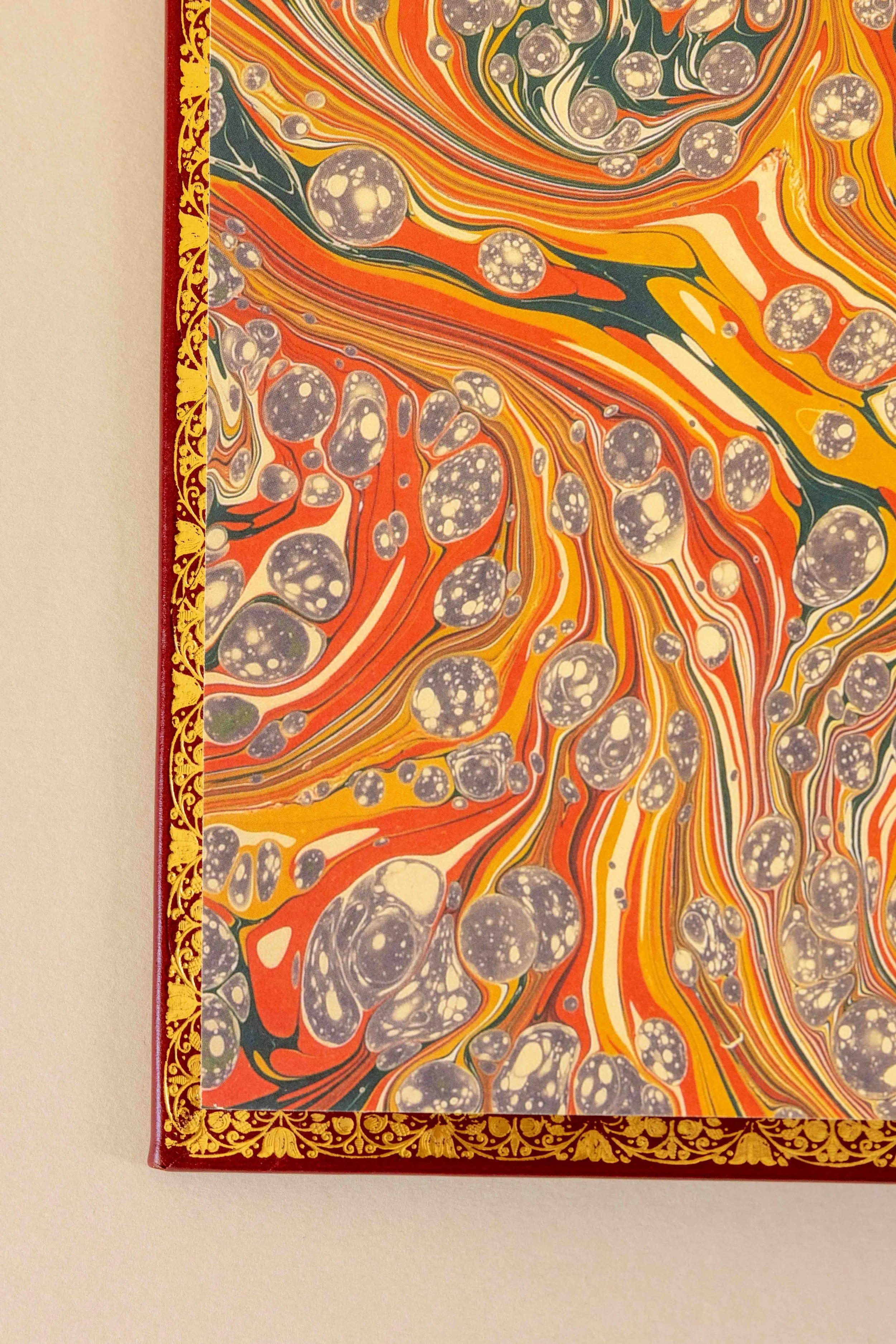 Close-up of a marbled paper book cover with a gold decorative border on the left side.