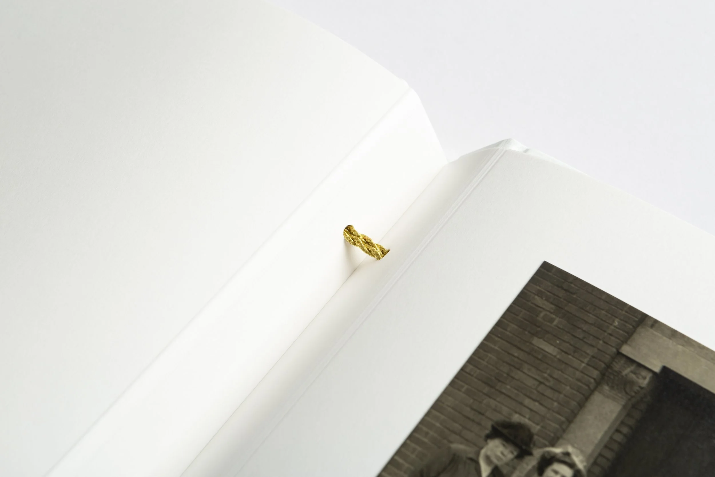 Open photo album with black and white photo of two young children standing outdoors.