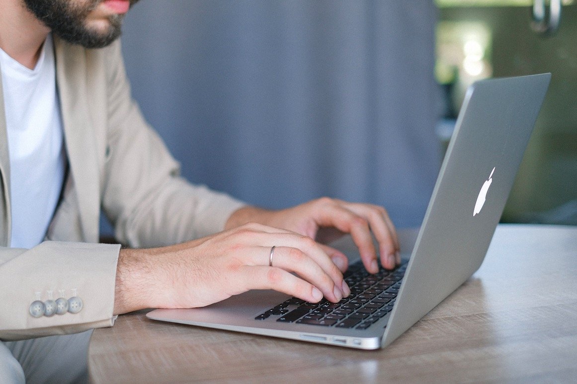 man typing on laptop