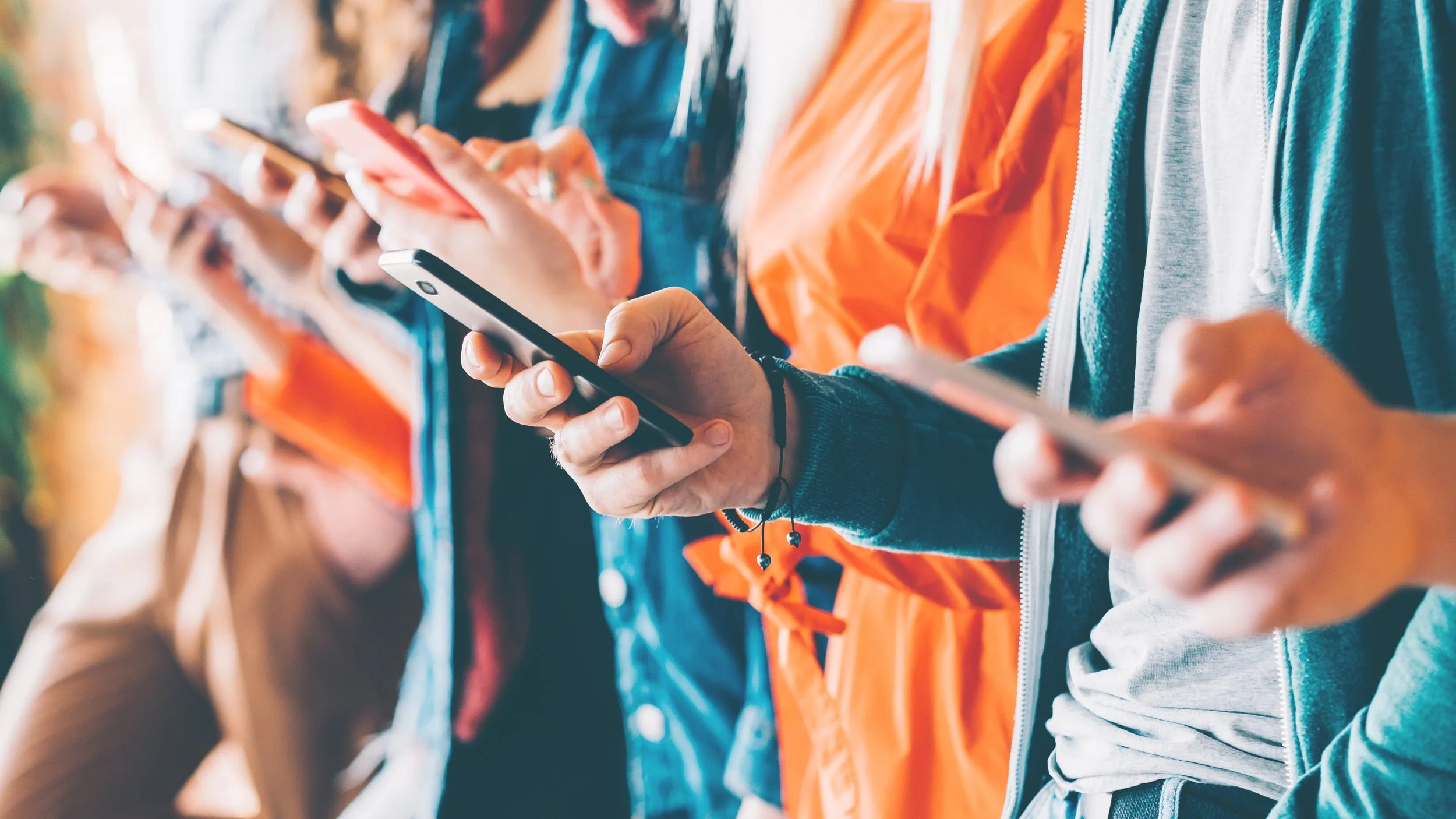 A group of teenagers holding a phone on their hand