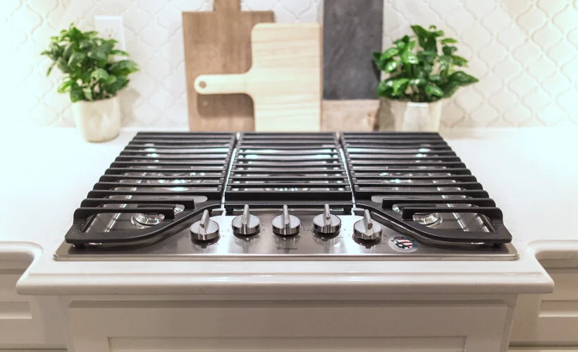 A kitchen in Salem, Oregon with a Carrara quartz countertop with an Ogee Edge detail, and a range top stove.