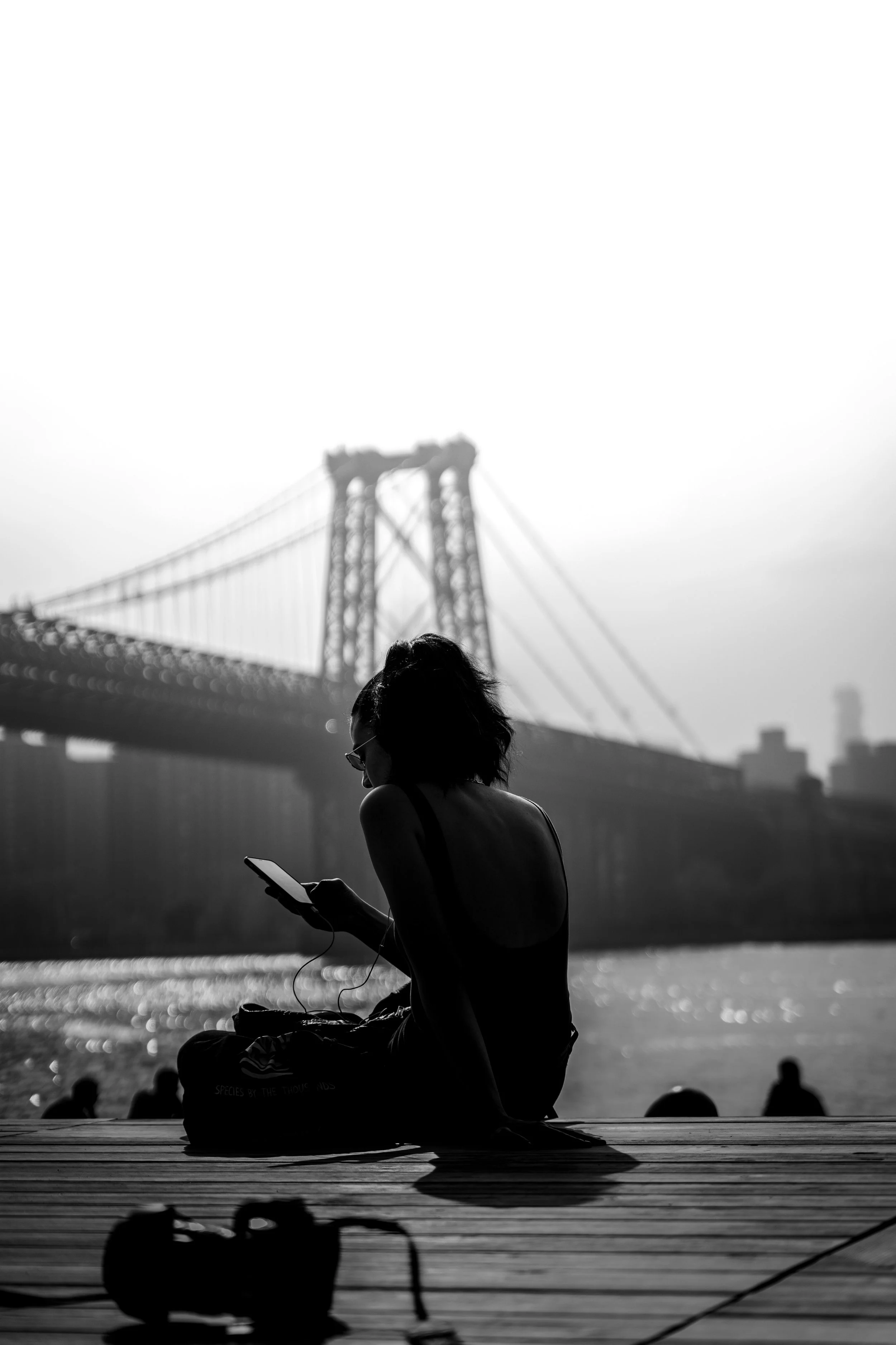 Back view of a woman sitting by the water