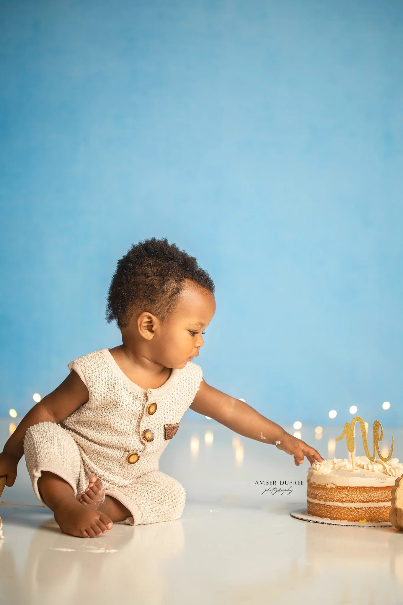 simple nashville cake smash photoshoot with blue backdrop