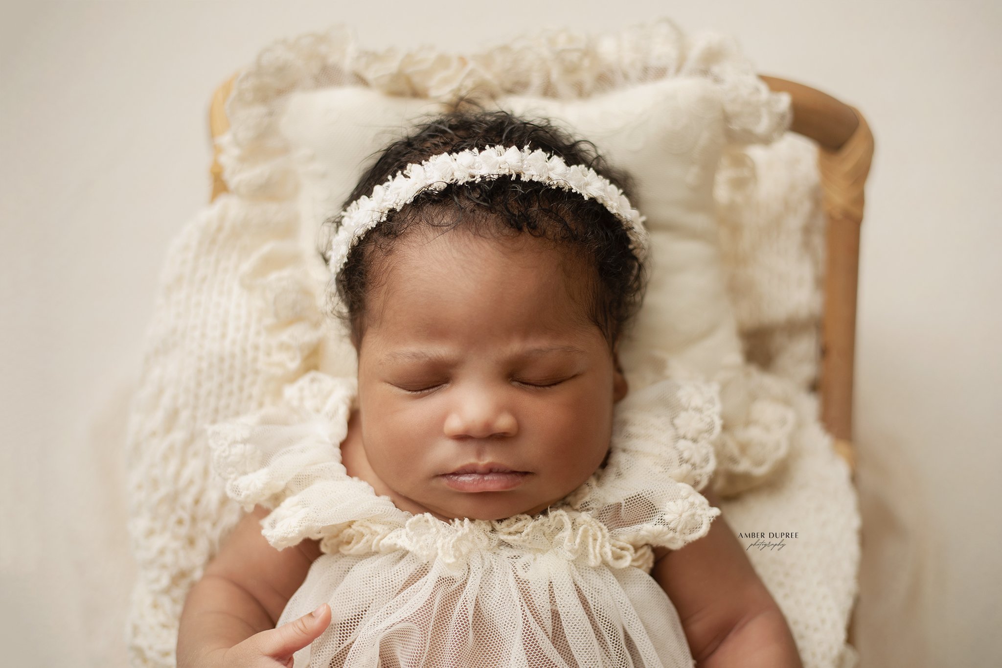 Nashville newborn photographer capturing a peaceful sleeping newborn wrapped in soft neutral tones in a studio setting