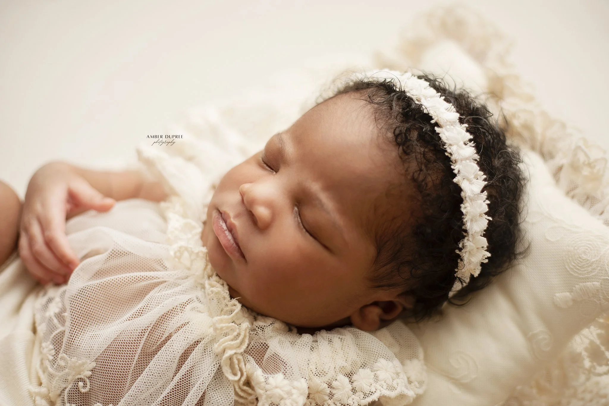 Nashville newborn photographer capturing a peaceful sleeping newborn wrapped in soft neutral tones in a studio setting