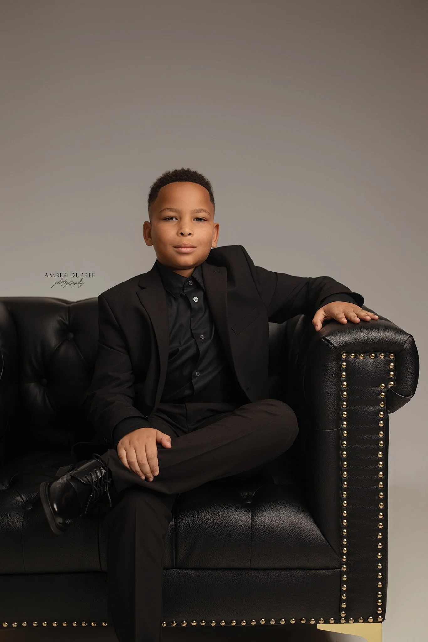 boy portraits posed in oversized leather chair in nashville, tn photography studio