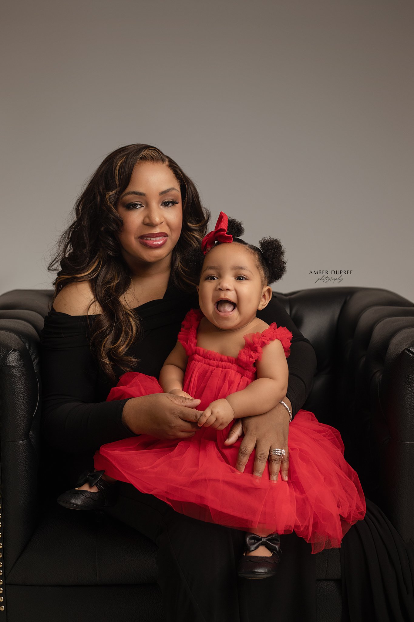 mom and daughter posed in an oversized leather chair in nashville photography studio