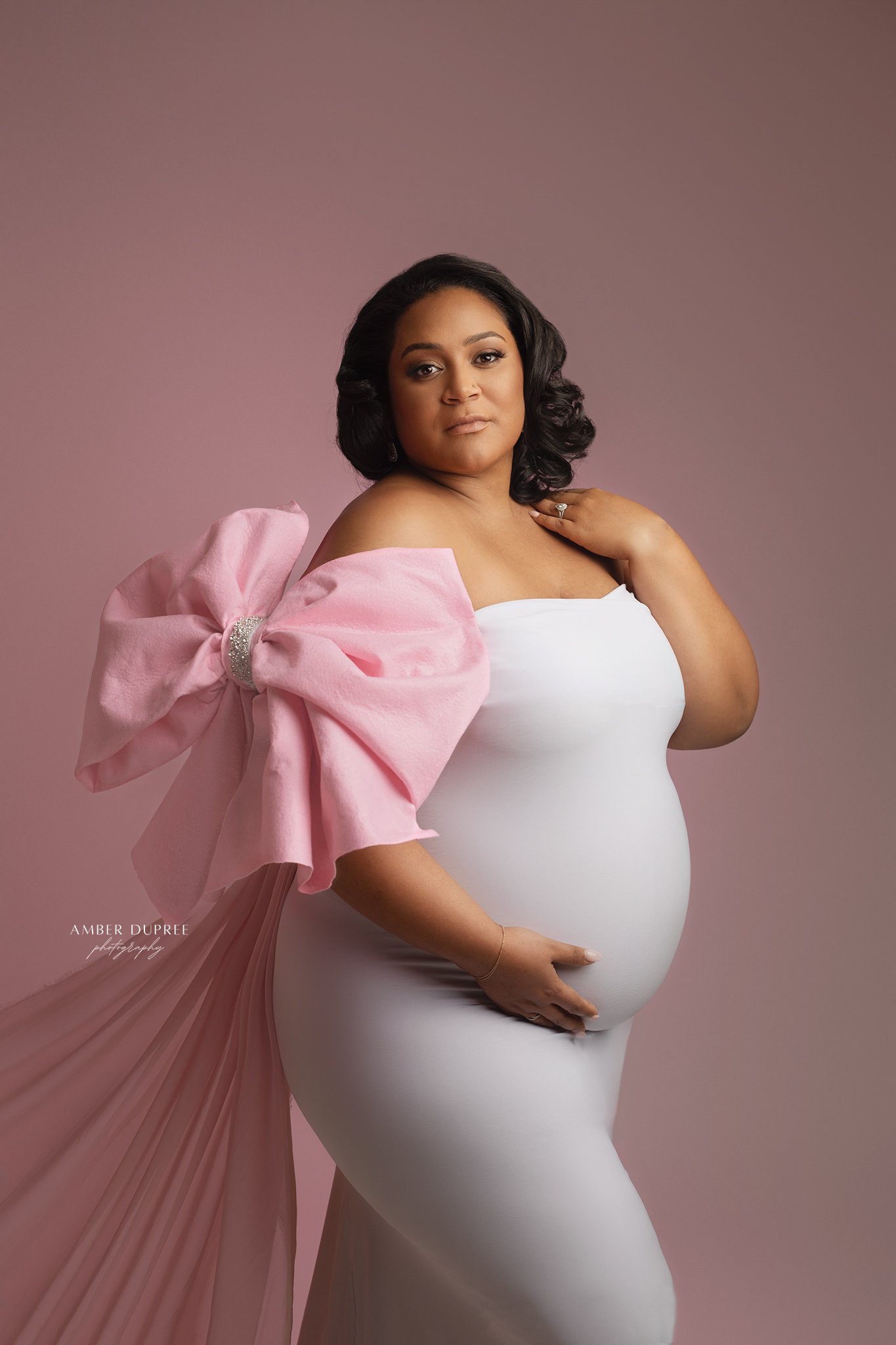 Luxury maternity photography portrait featuring a flowing gown and editorial posing in a Nashville studio.