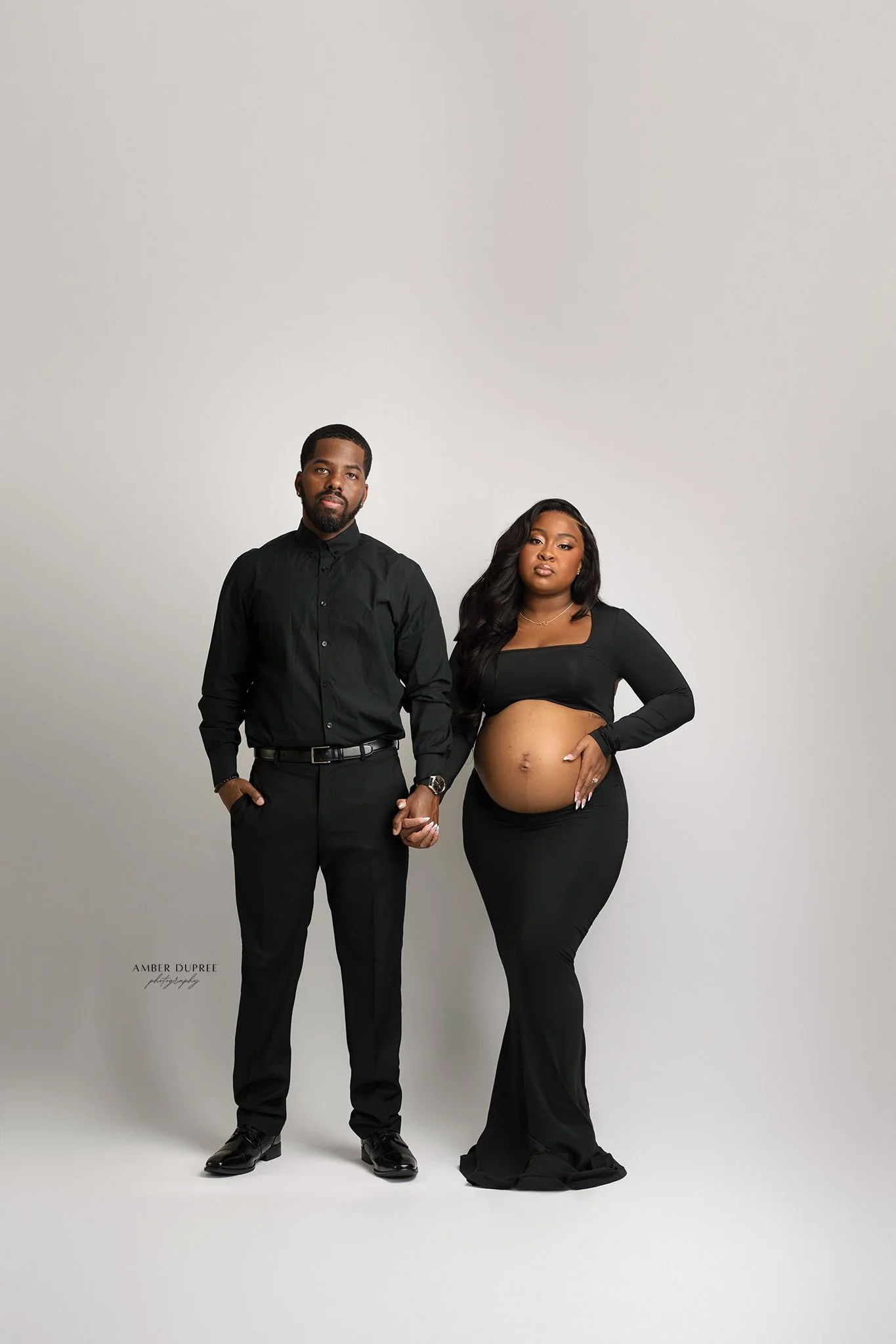 editorial maternity photoshoot with husband and wife in a all black on a white backdrop in nashville maternity photography studio