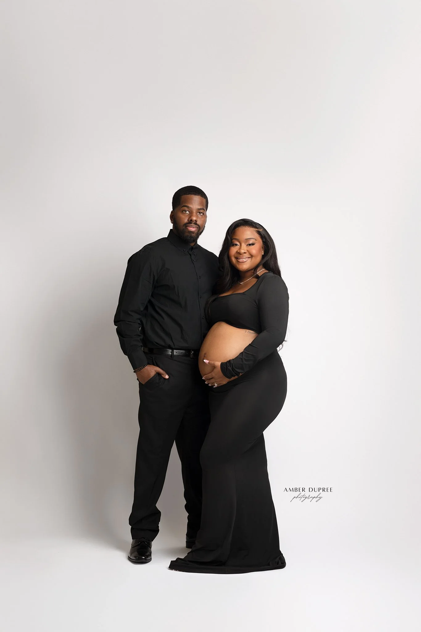 editorial maternity photoshoot with husband and wife in a all black on a white backdrop in nashville maternity photography studio