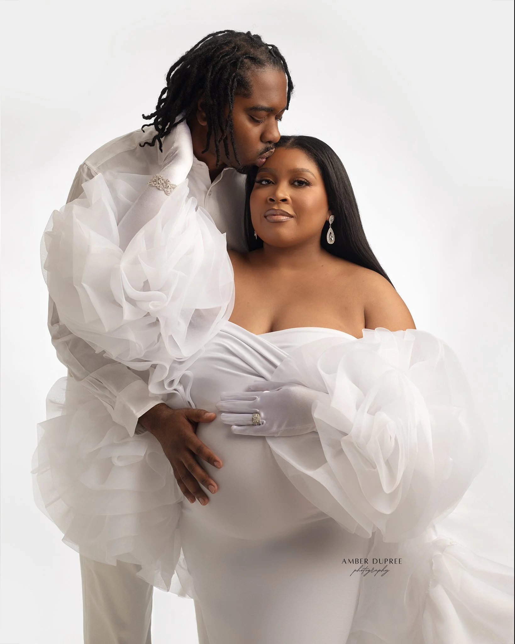 husband and wife posing for maternity photoshoot