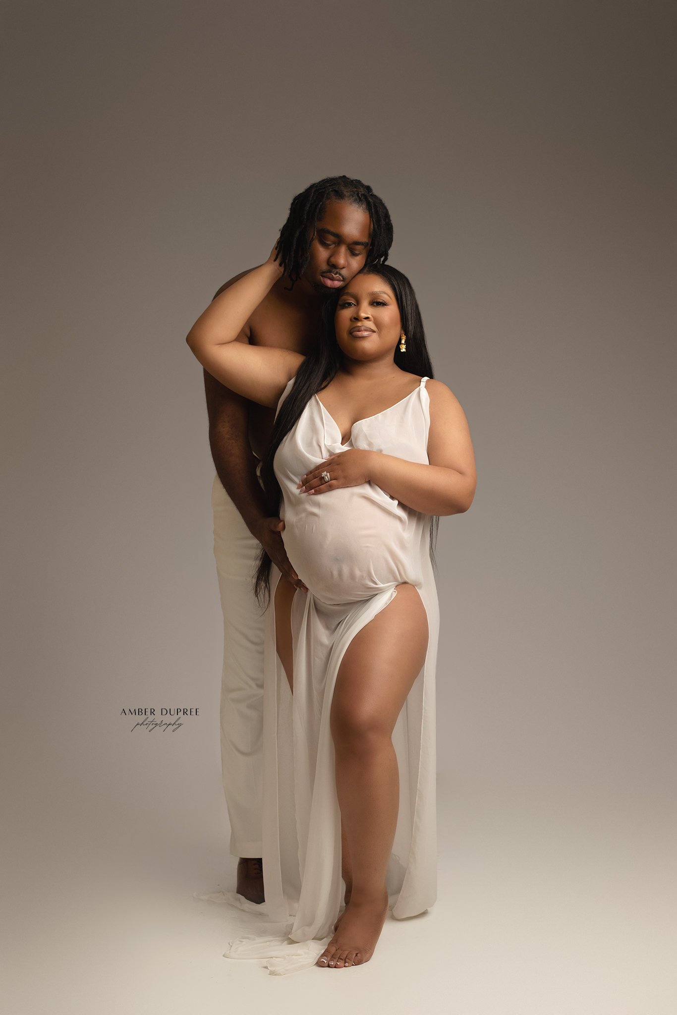 luxury maternity photos with husband nashville studio portrait of couple embracing during pregnancy