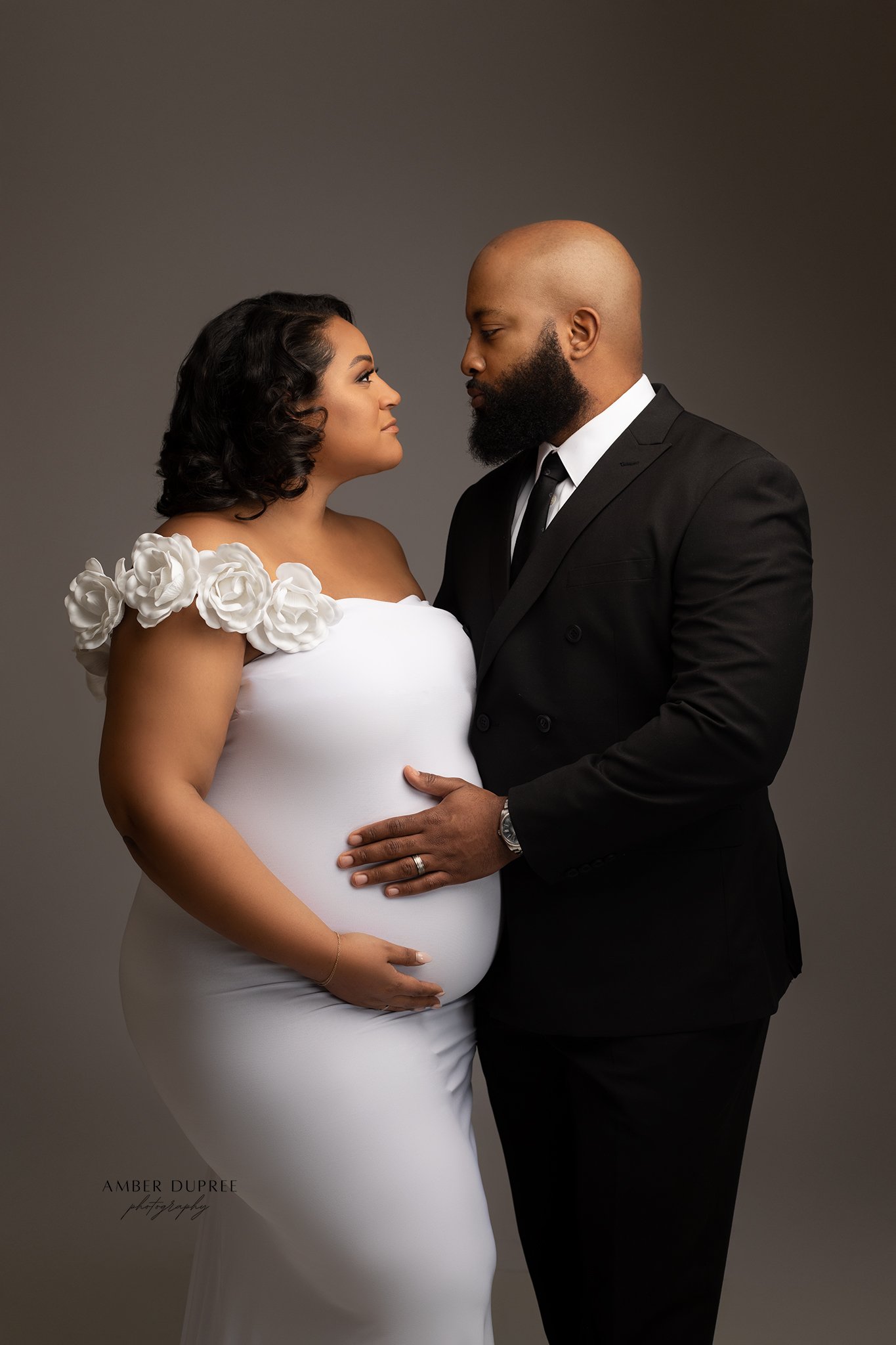 editorial maternity photoshoot nashville couple posing with dramatic studio lighting