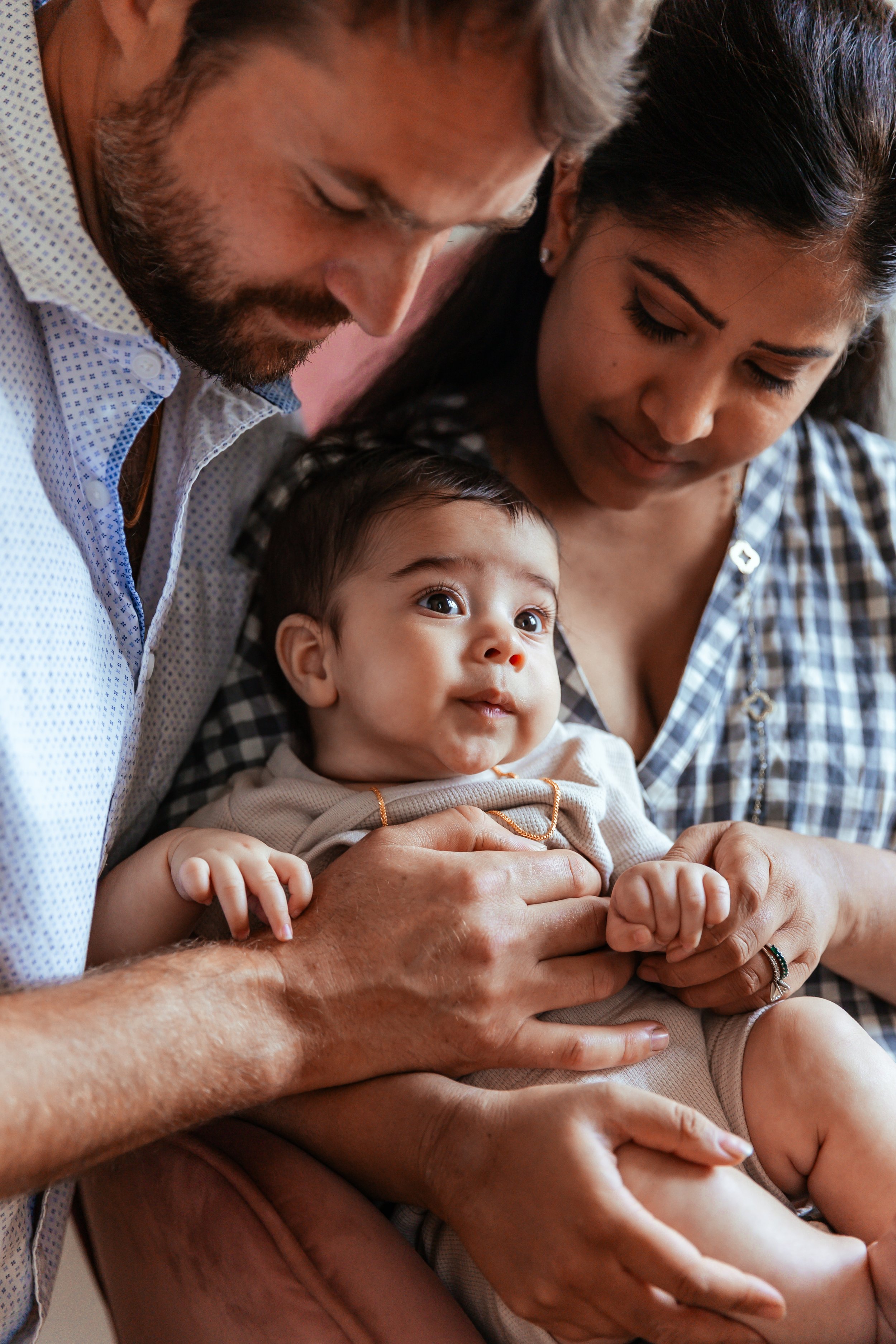 A man and woman lovingly holding a baby.