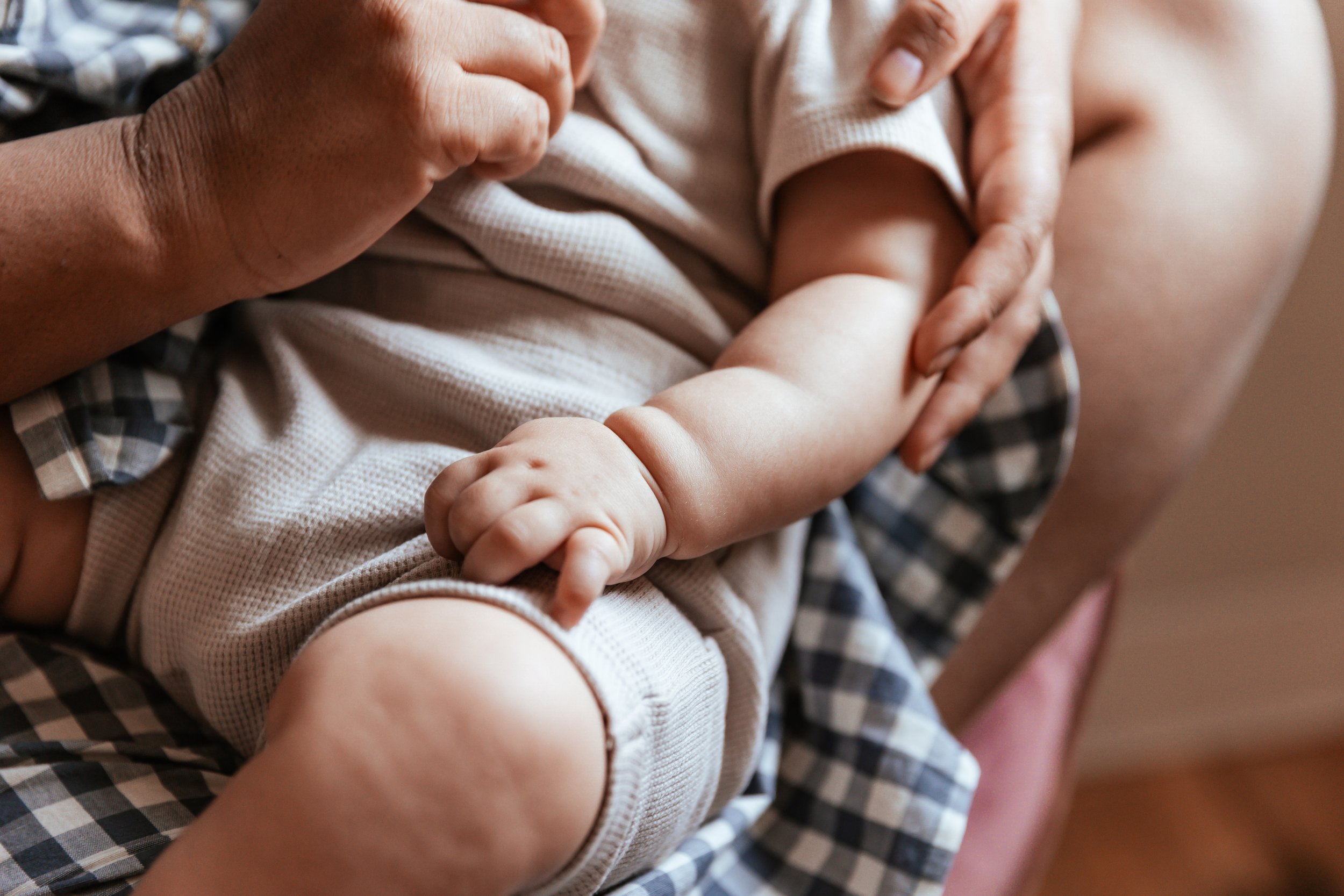 Close-up of a baby held by an adult