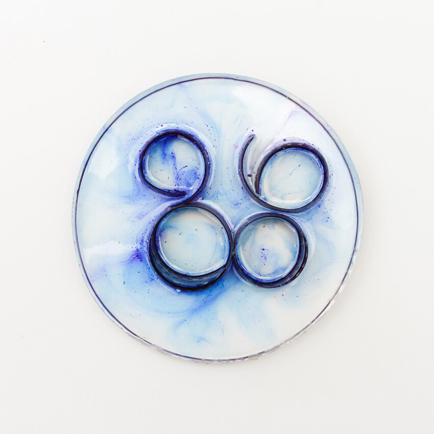   Title: Traces #5 Dimensions: 5” diameter, 1/3” depth Medium: Photographic film, resin, India ink, glass etching medium  