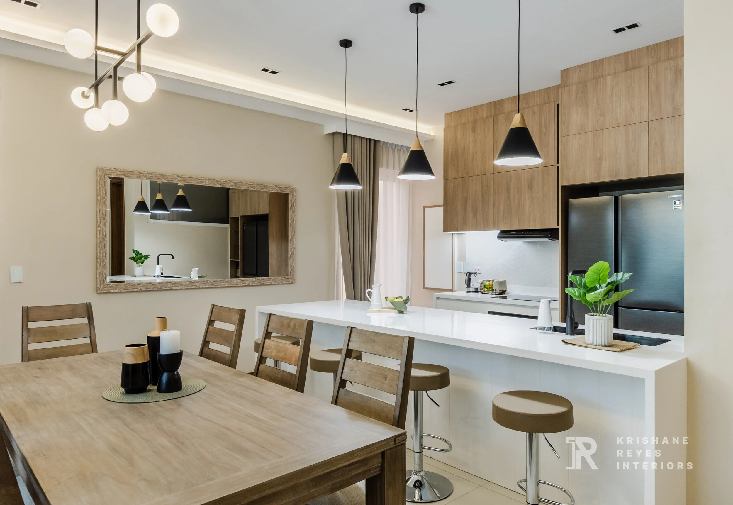 Modern open-concept kitchen and dining area with wooden accents, black and pendant lighting, and a large mirror.