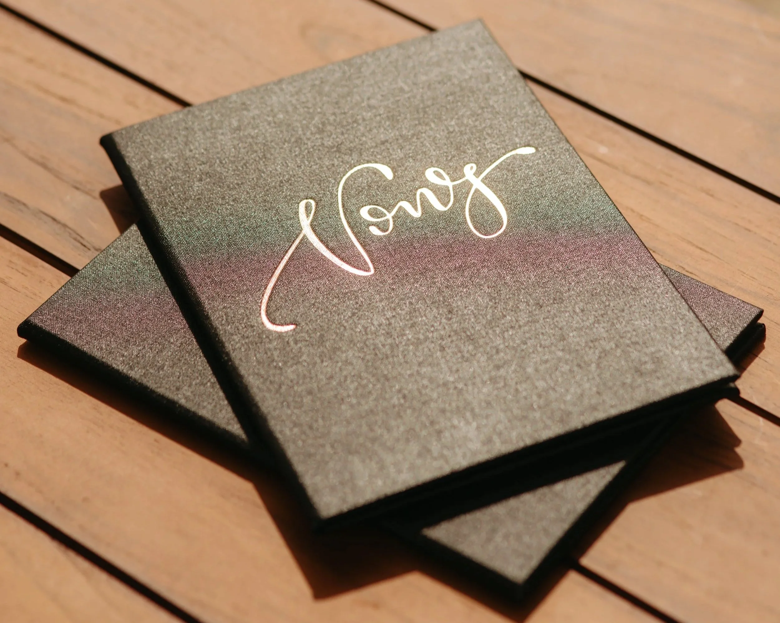 A black box with the word "Love" written in cursive white letters, sitting on a wooden surface.