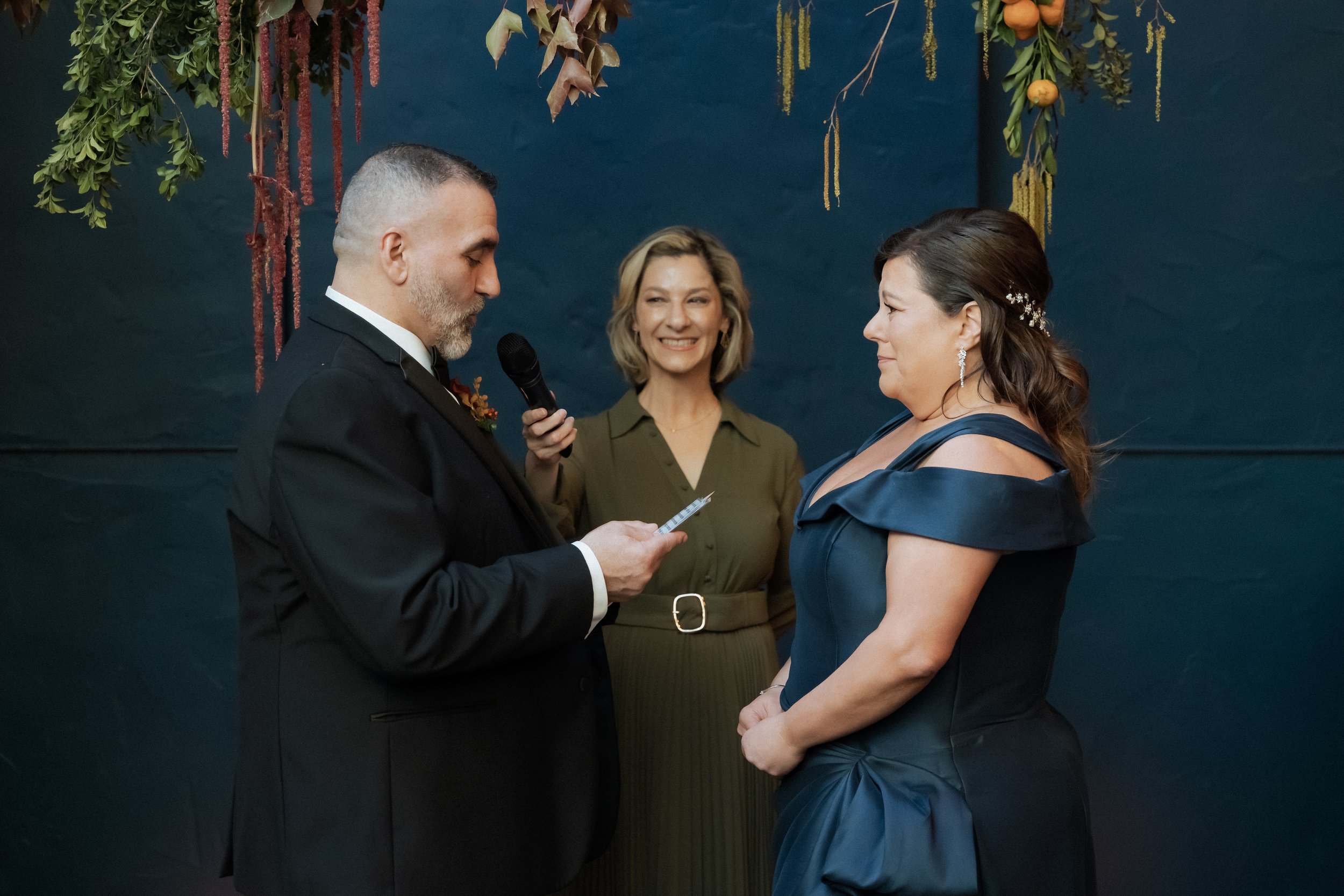 Happy Melbourne Marriage Celebrant standing between a happy looking couple about to say their vows at their wedding ceremony in Melbourne
