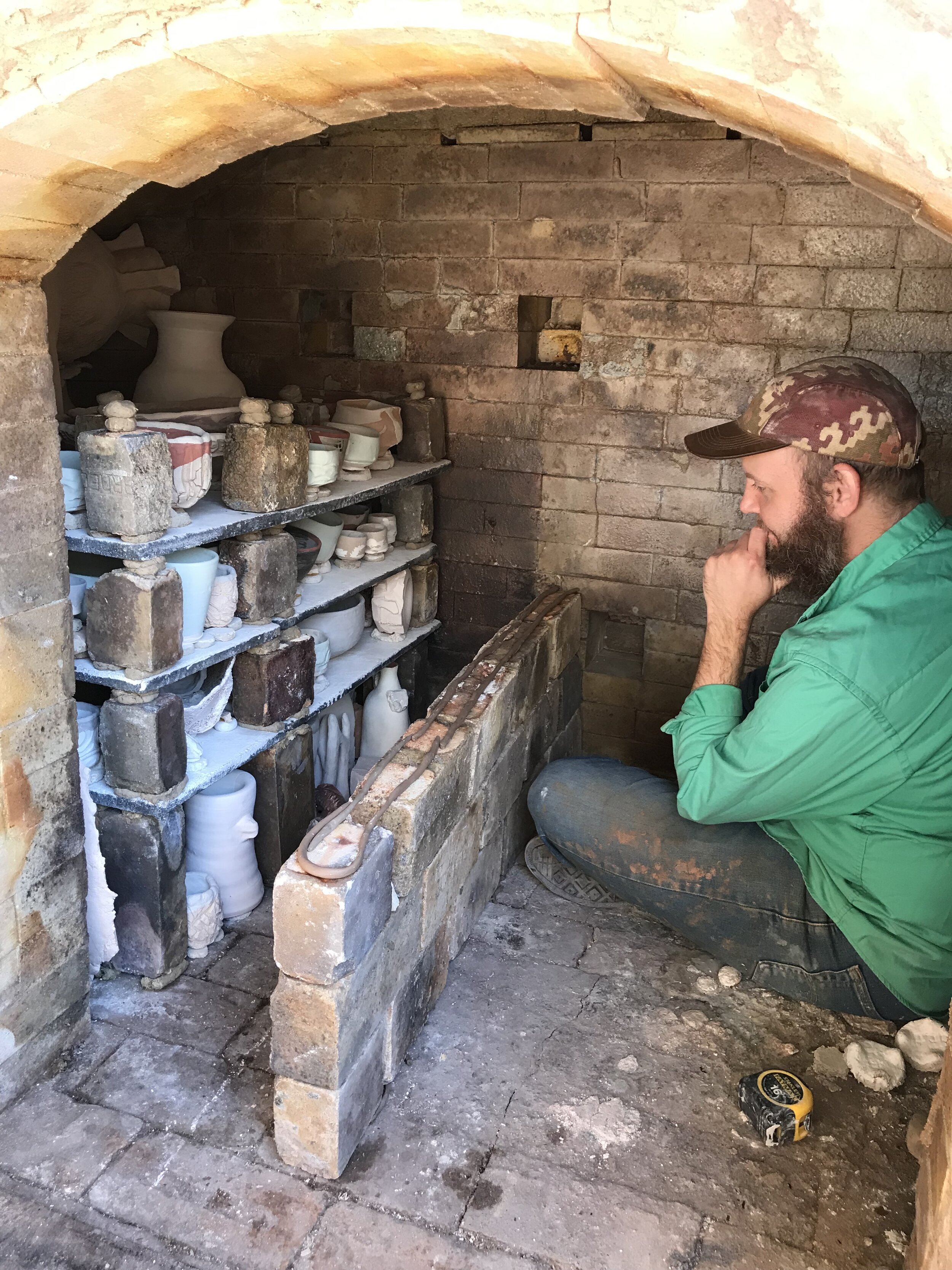 Contemplating the shelf stack behind the bag wall of a train kiln